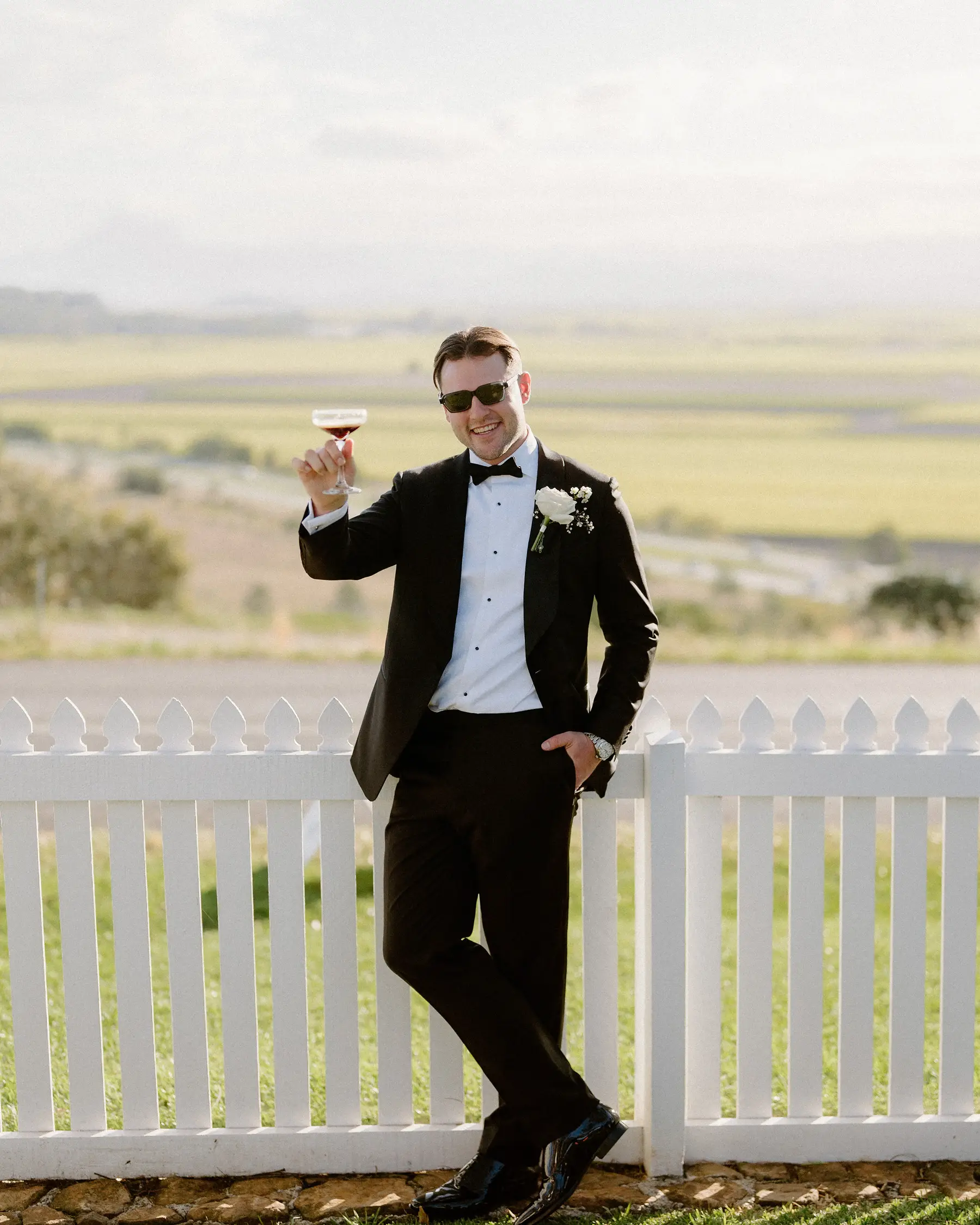 Raising a glass by the picket fence above the cane fields, Botanica Plantation House