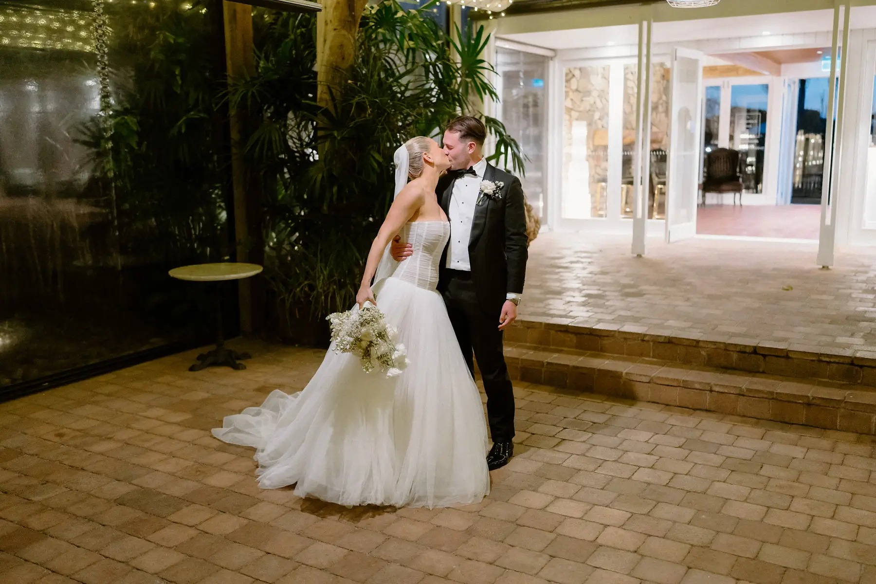 A kiss on the reception floor beneath the fairy lights, Botanica Plantation House