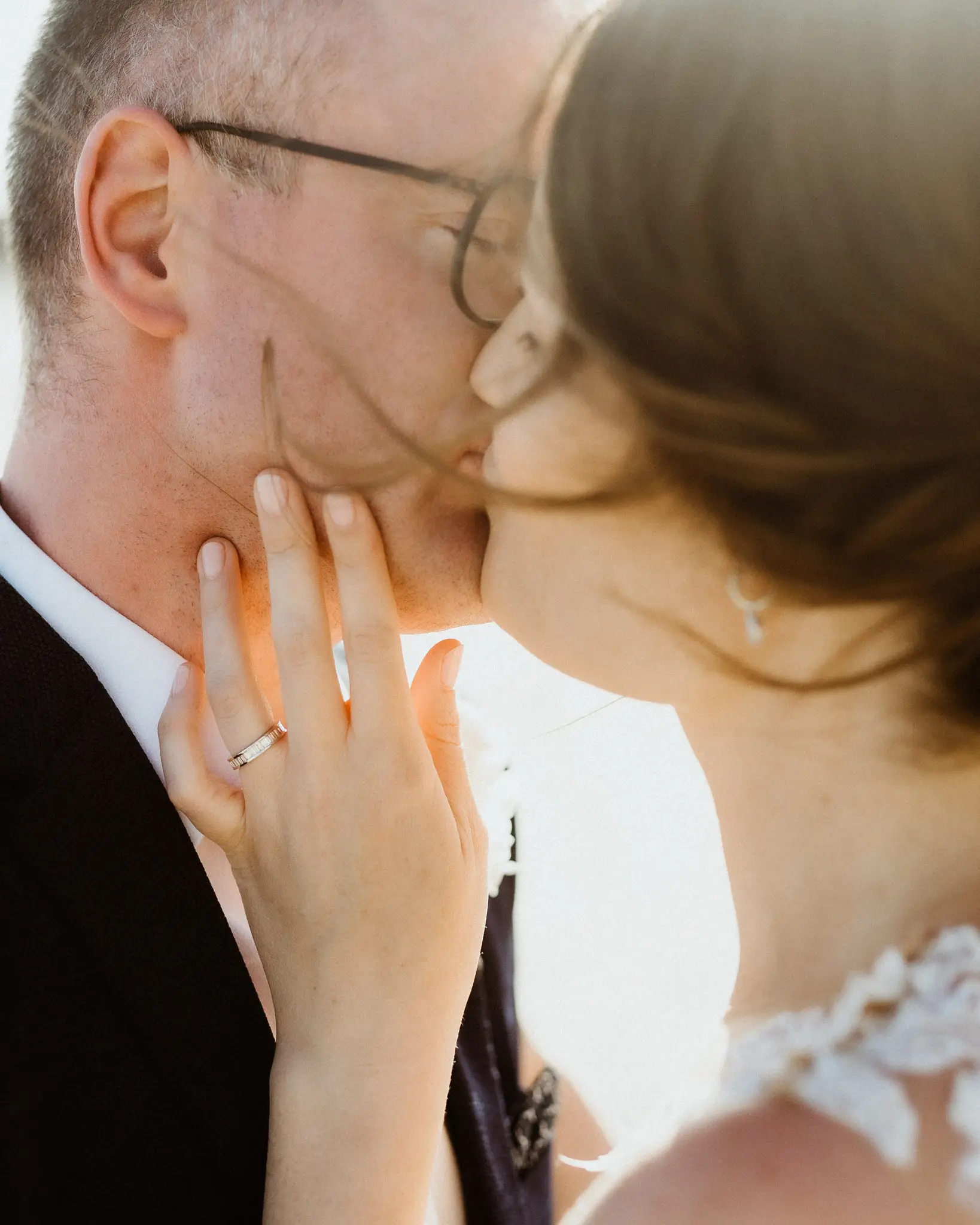 Close frame of a kiss, her hand resting on his jaw