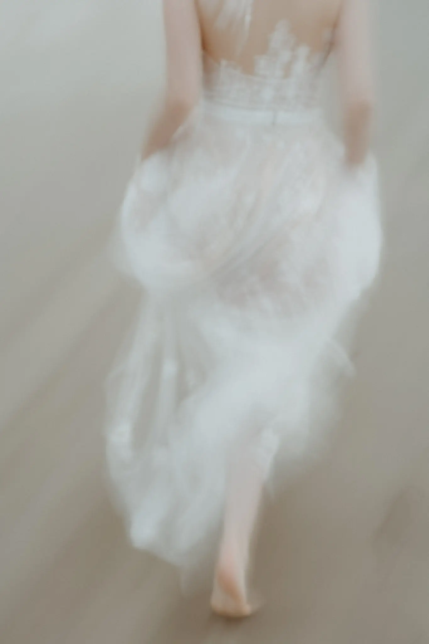 The bride's dress in motion, barefoot on wet sand