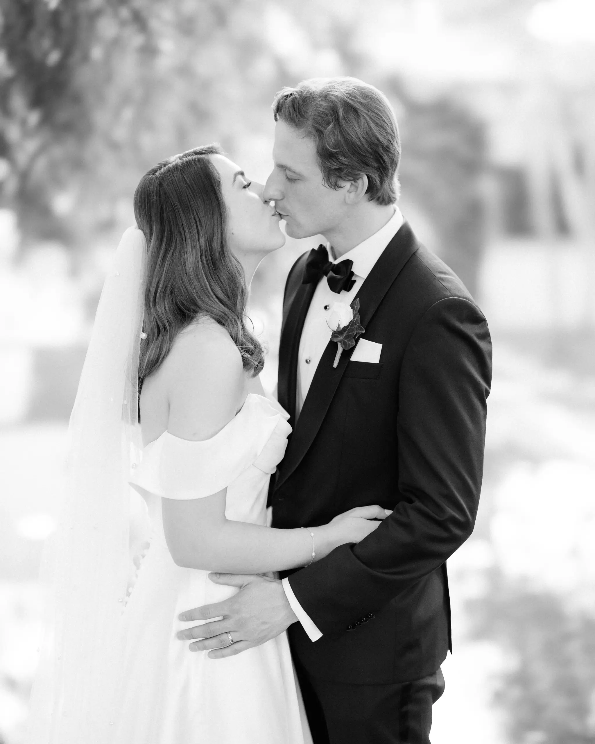 A kiss in the garden after the ceremony, in black and white