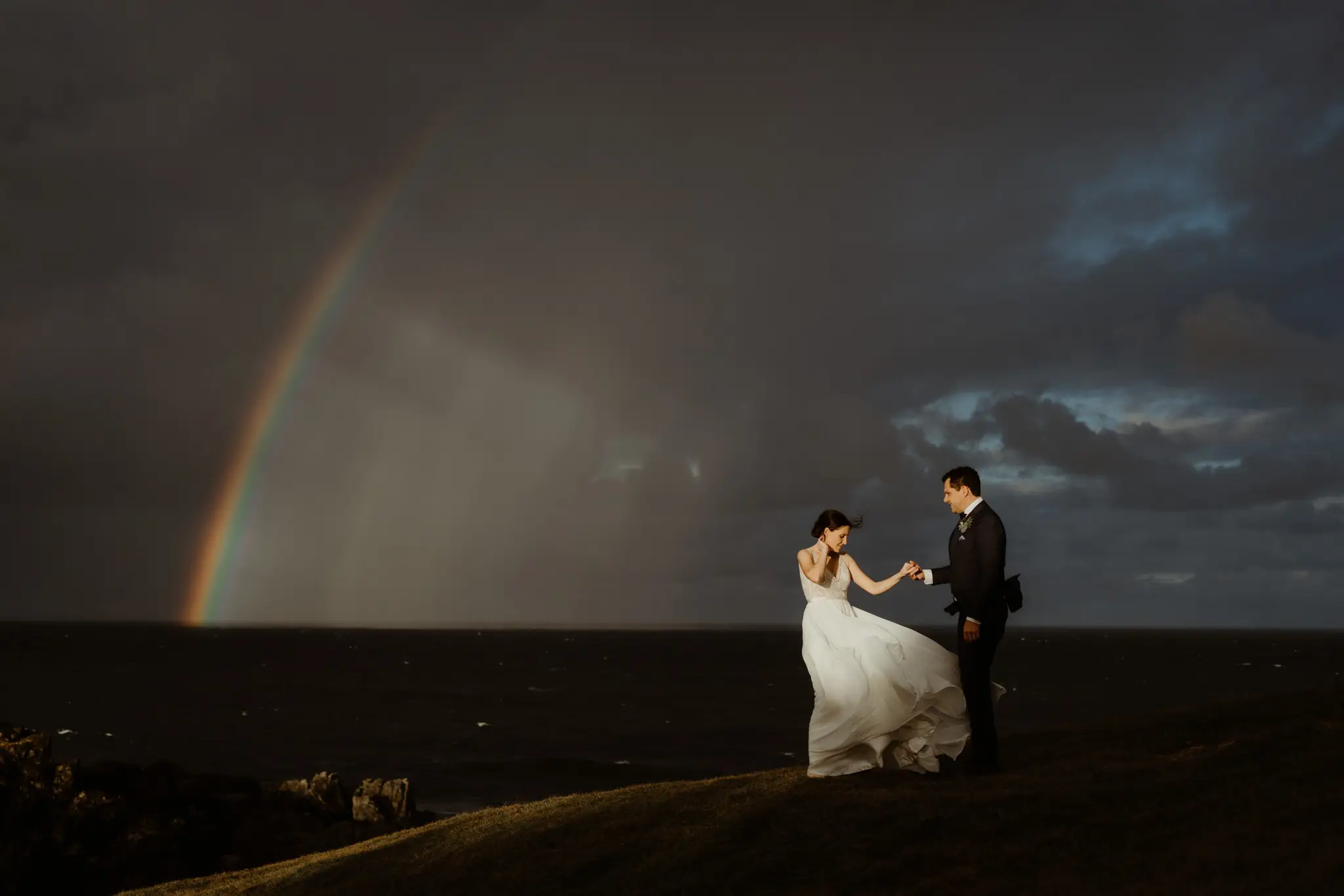 Double rainbow over the sea, the couple on the headland below
