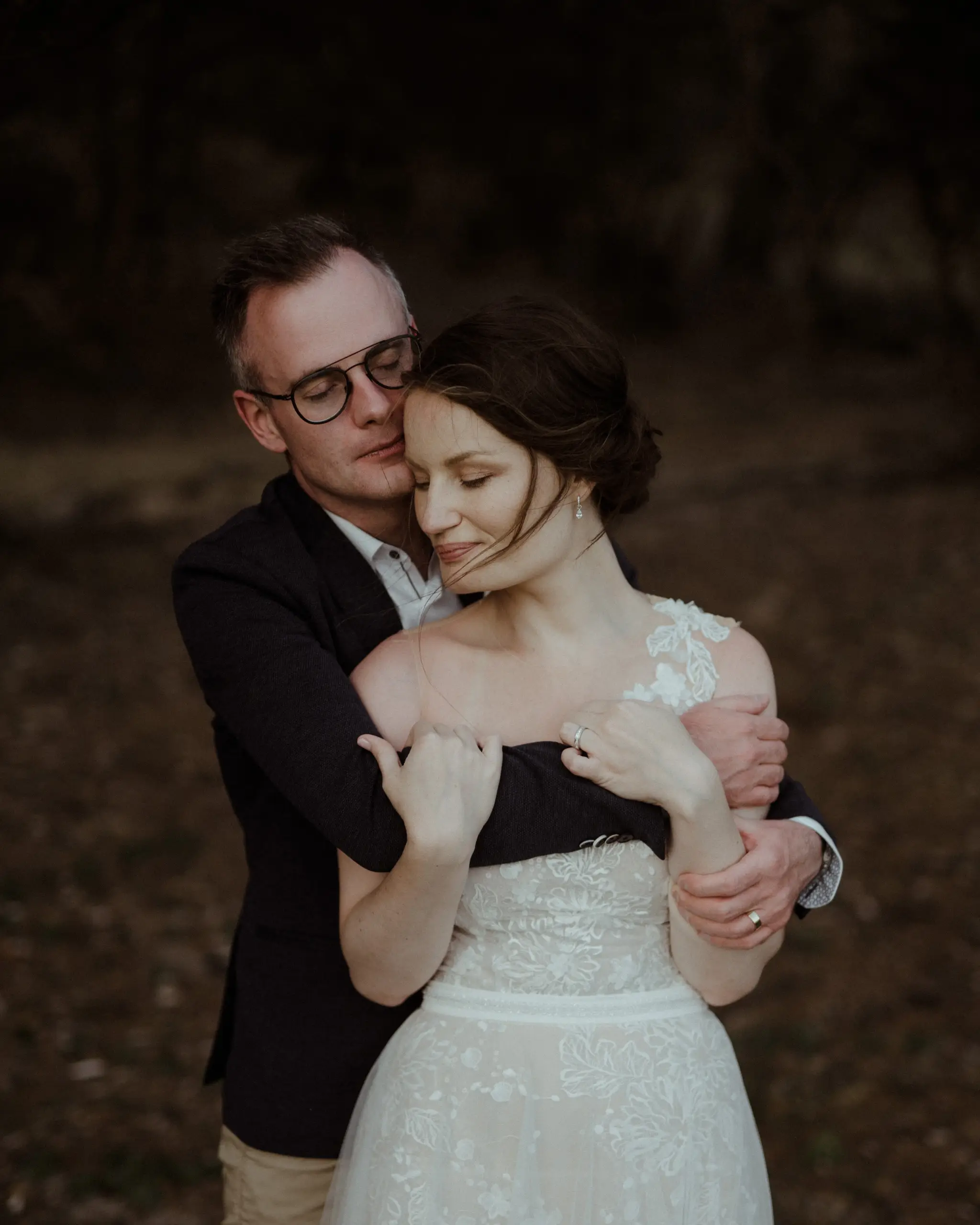 Groom holding the bride from behind in the last light