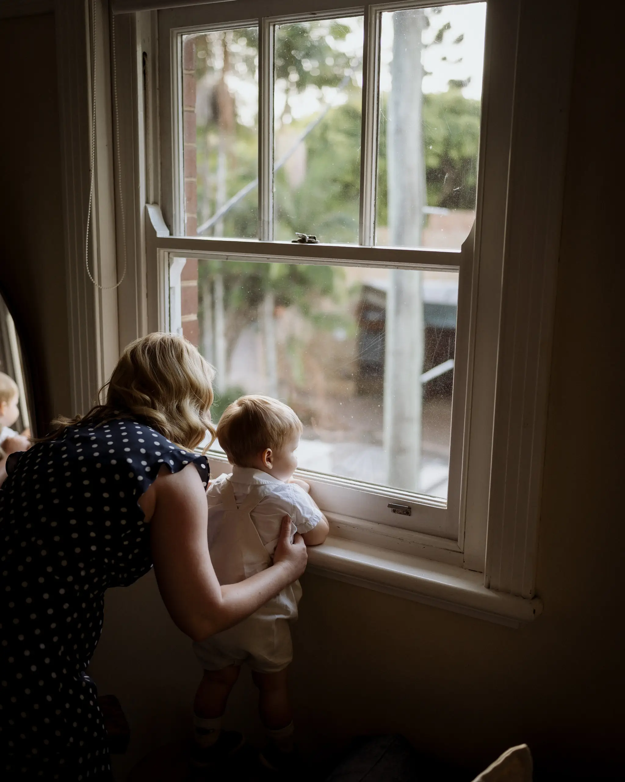 Mother and baby watching out the window before the ceremony