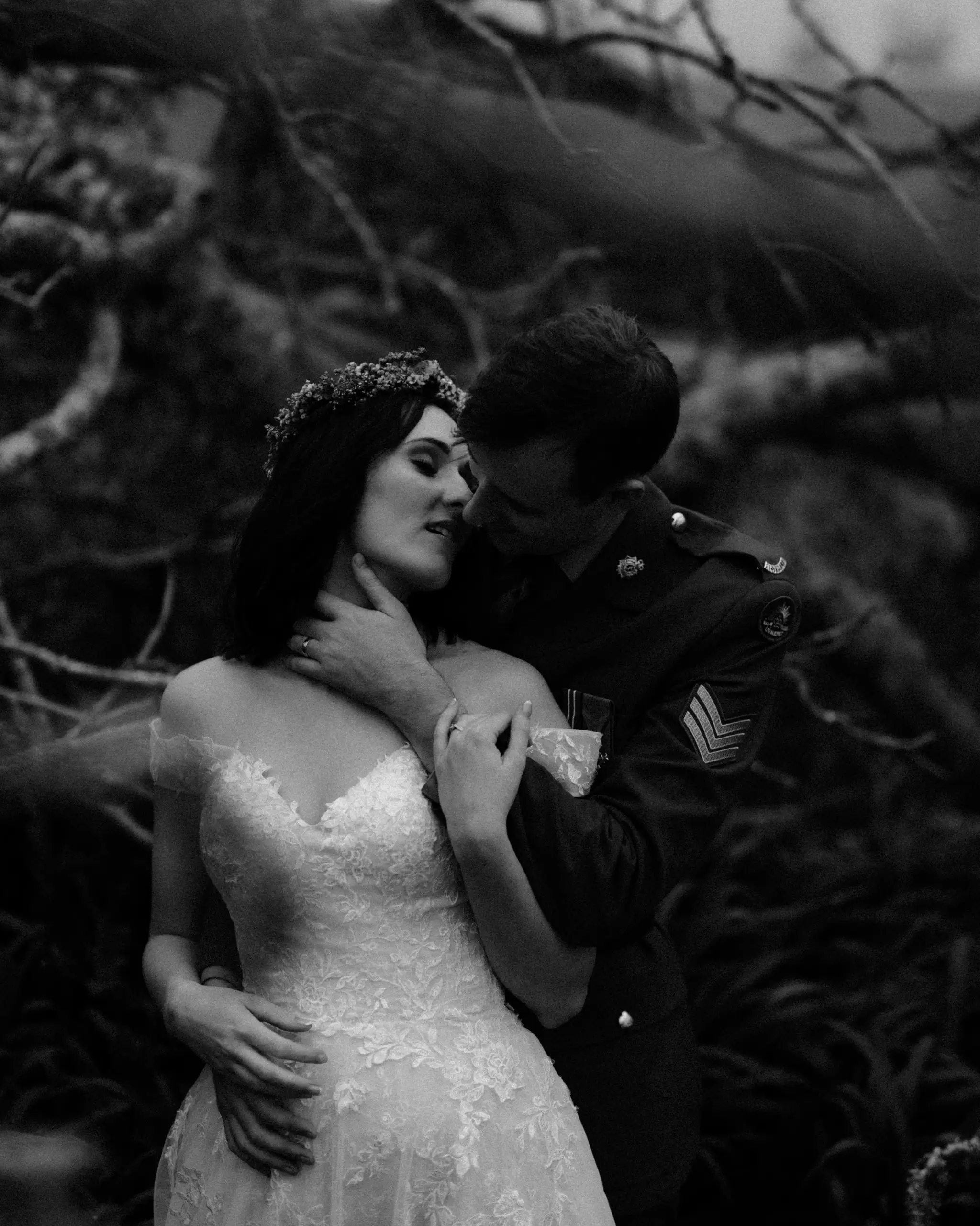 Couple pressed into dark coastal tea-trees