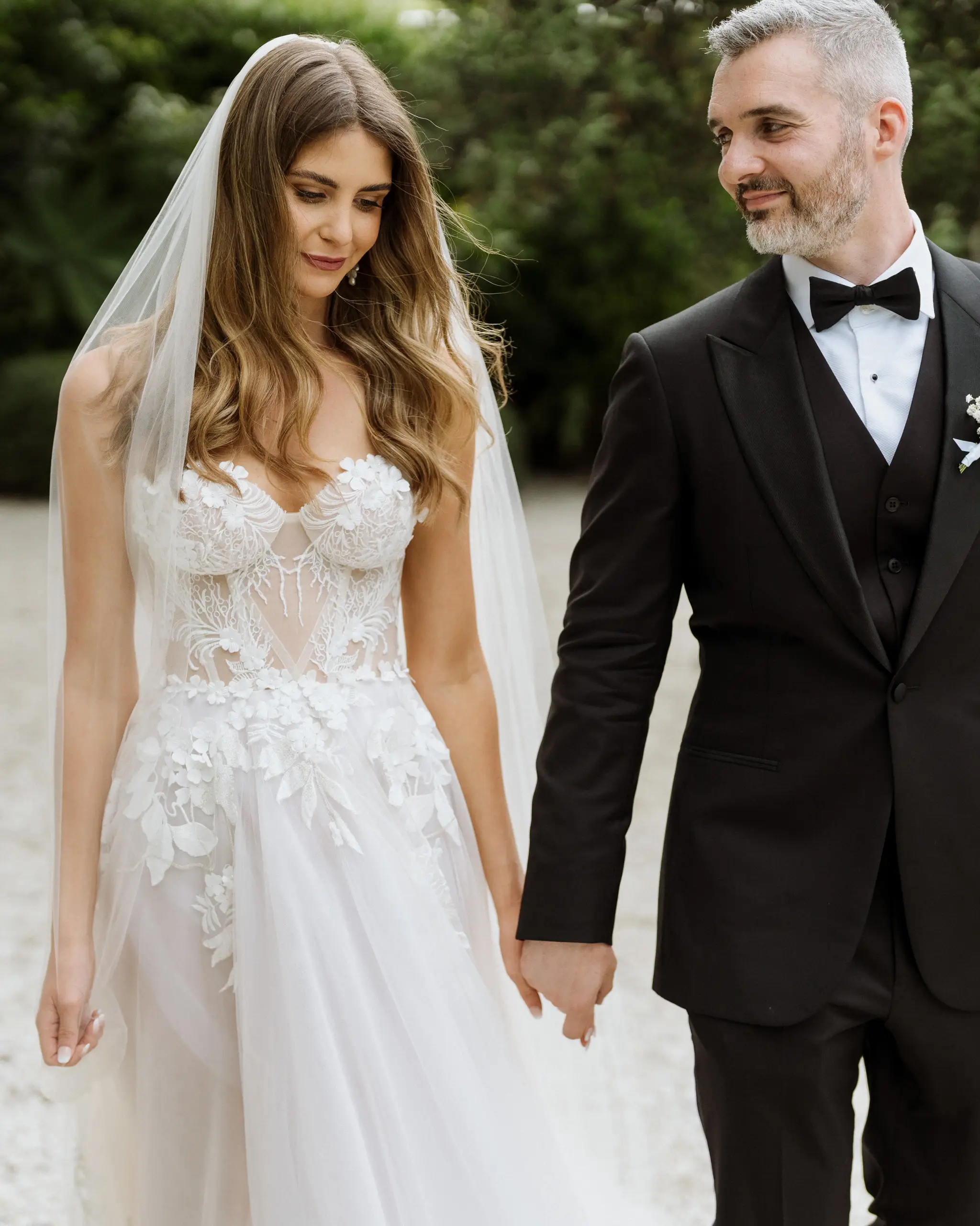 Bride and groom hand in hand in the garden