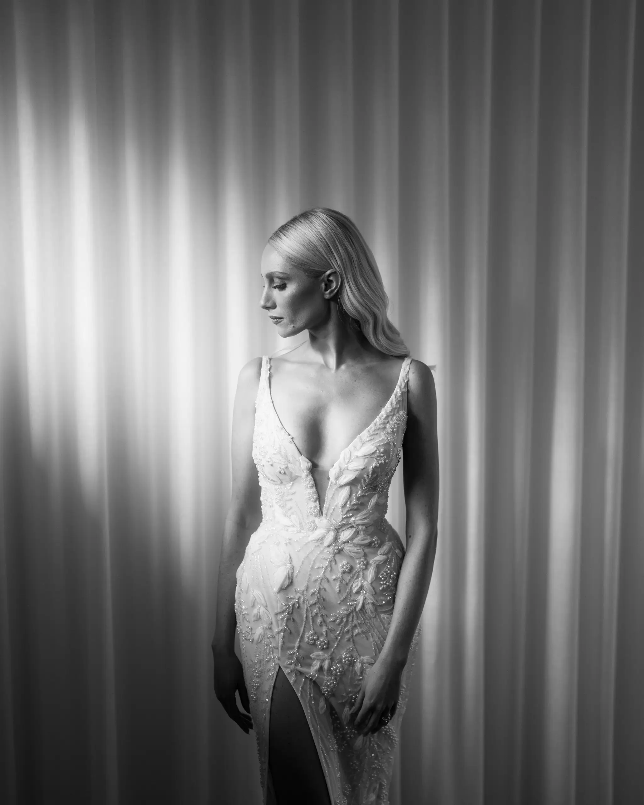 Bride lit against a rippling white curtain