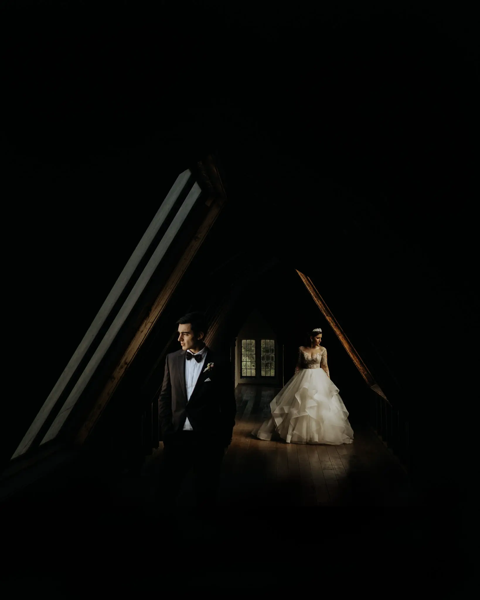 Bride and groom lit inside a dark timber A-frame