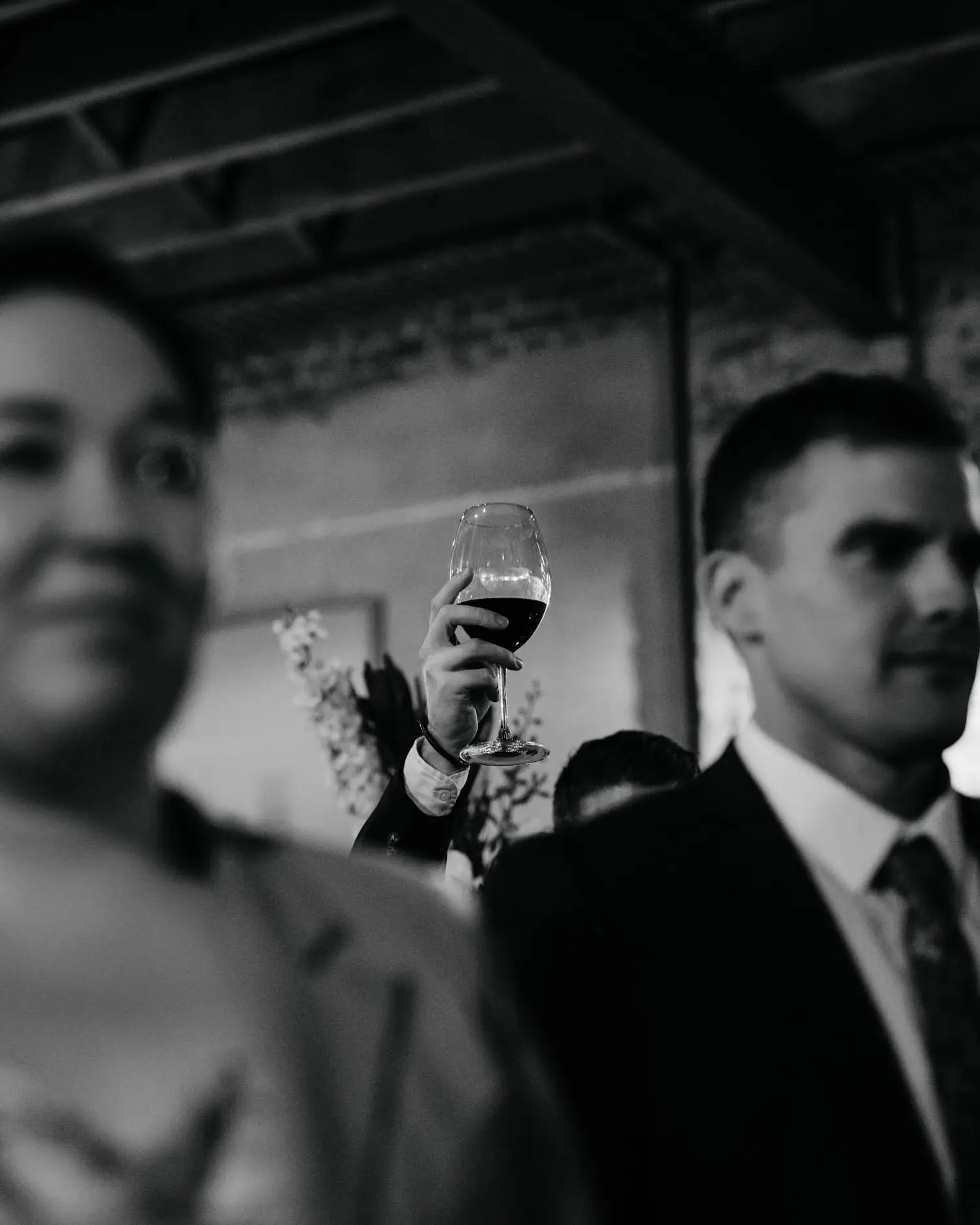 A raised glass across the warehouse reception, in black and white