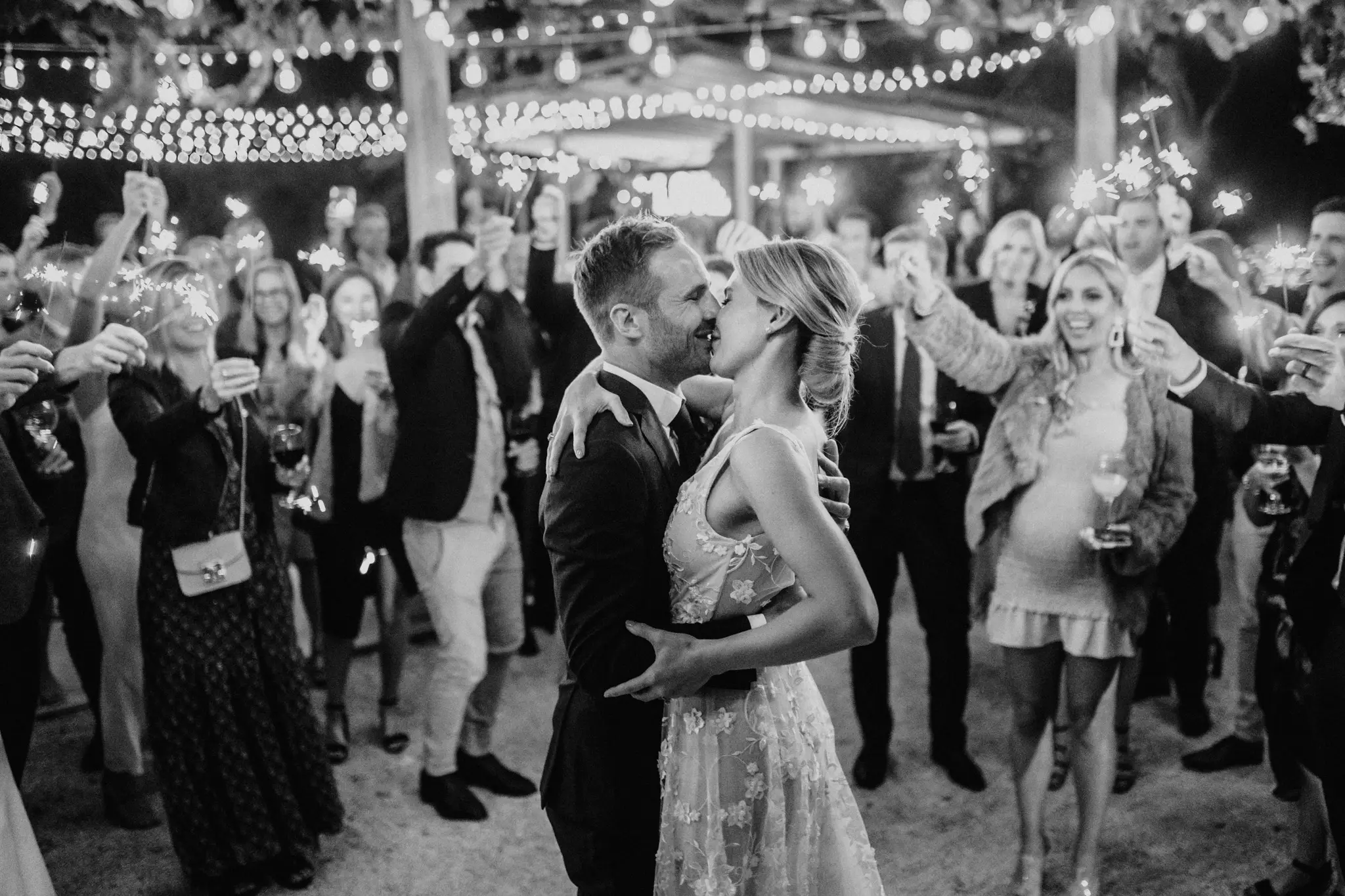 First dance under the lights with sparklers all around, in black and white