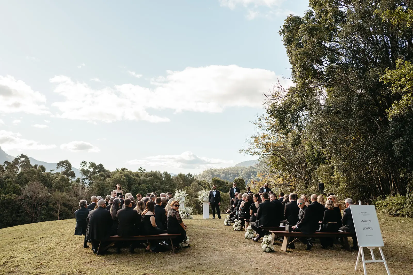The ceremony from the back of the lawn, cliffs on the horizon, The Bower Estate