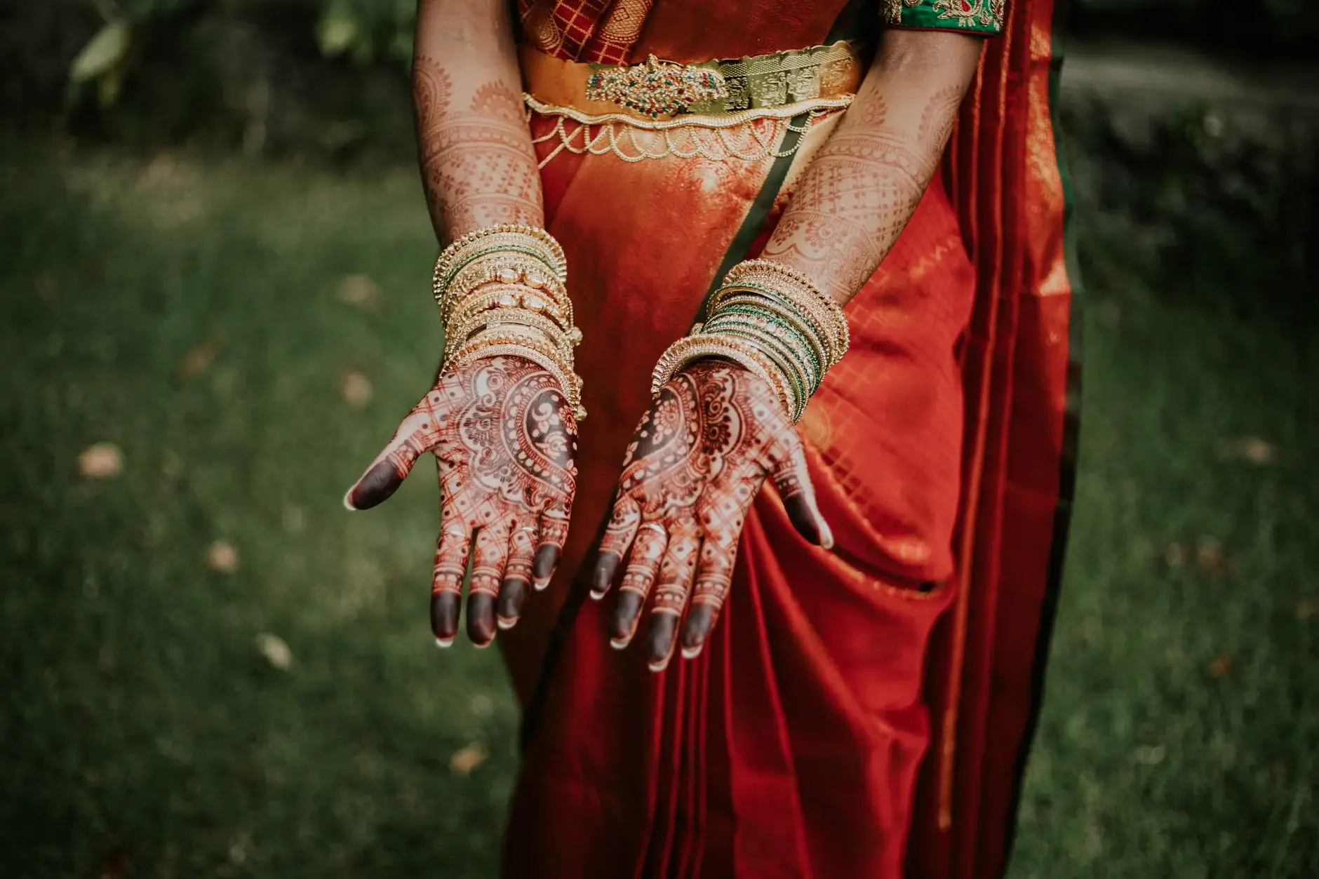 Priyanka’s hennaed hands held out against her red sari, Sydney