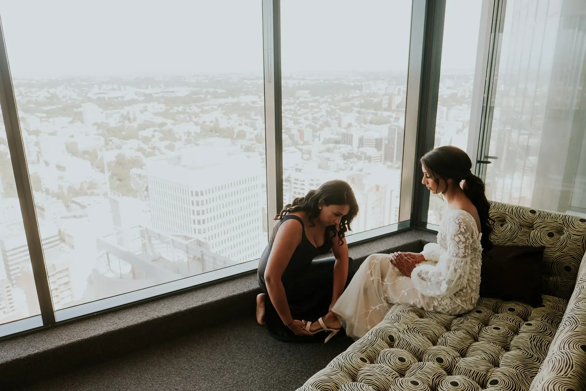 Priyanka sitting by the window with the city below, Sydney