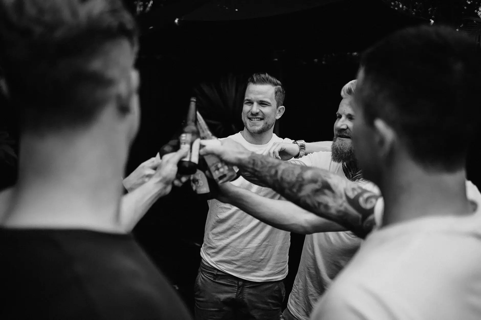 The groomsmen laughing and shoving each other in the garden, Byron Bay