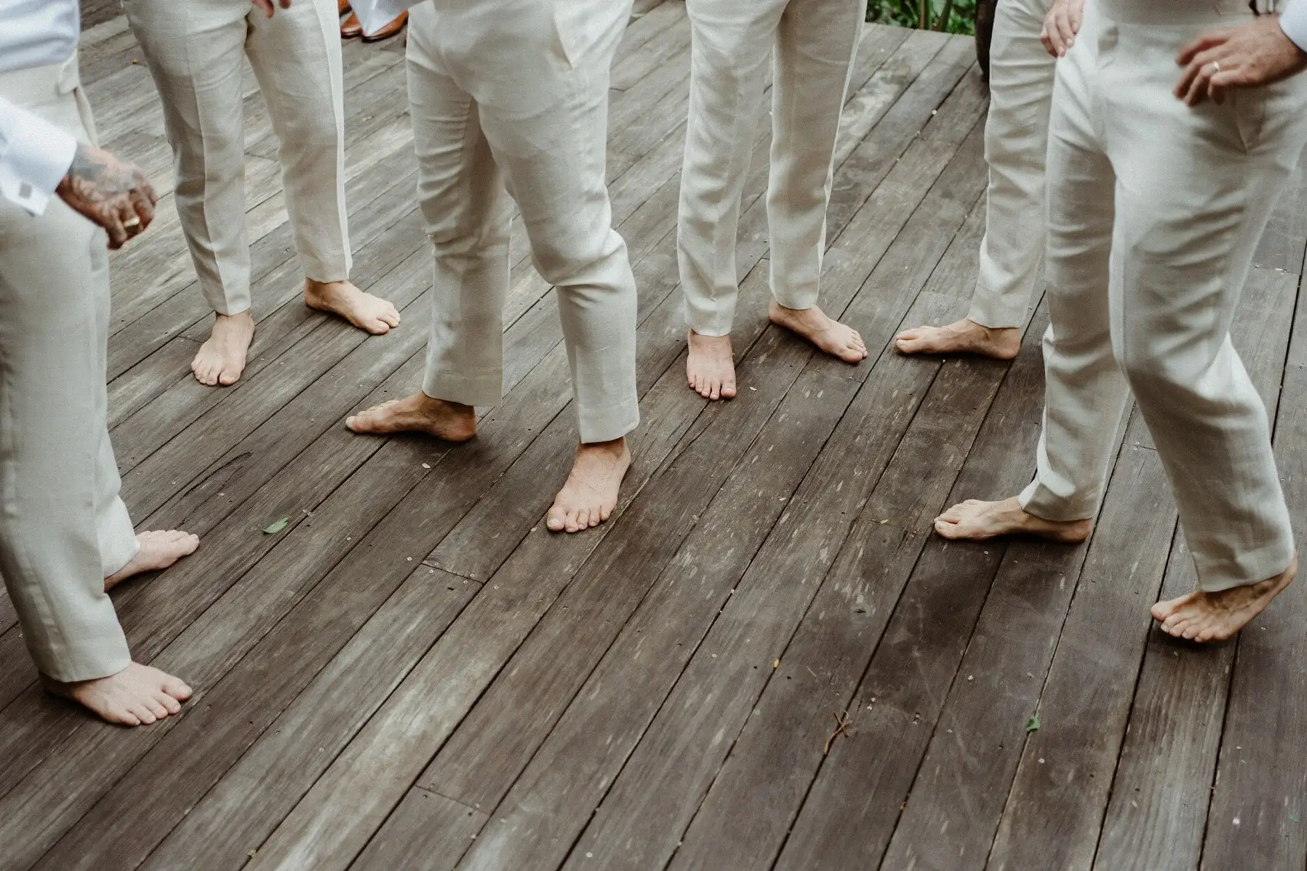 The groomsmen's bare feet on the timber deck in linen suits, Byron Bay