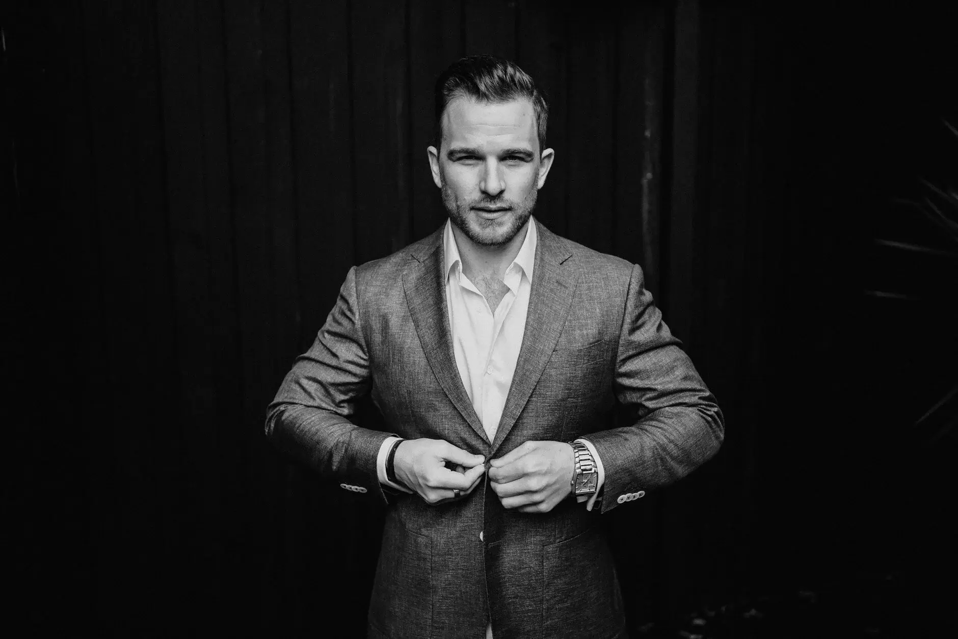 A black-and-white portrait of Matt buttoning his jacket, Byron Bay