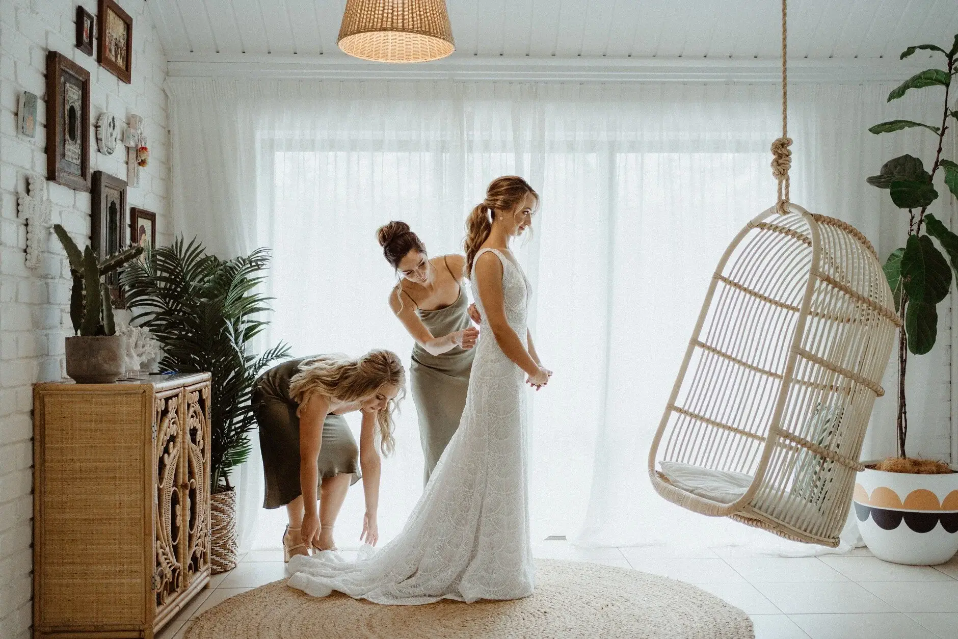 Breanna stepping into her Jane Hill gown beside a hanging chair, Byron View Farm