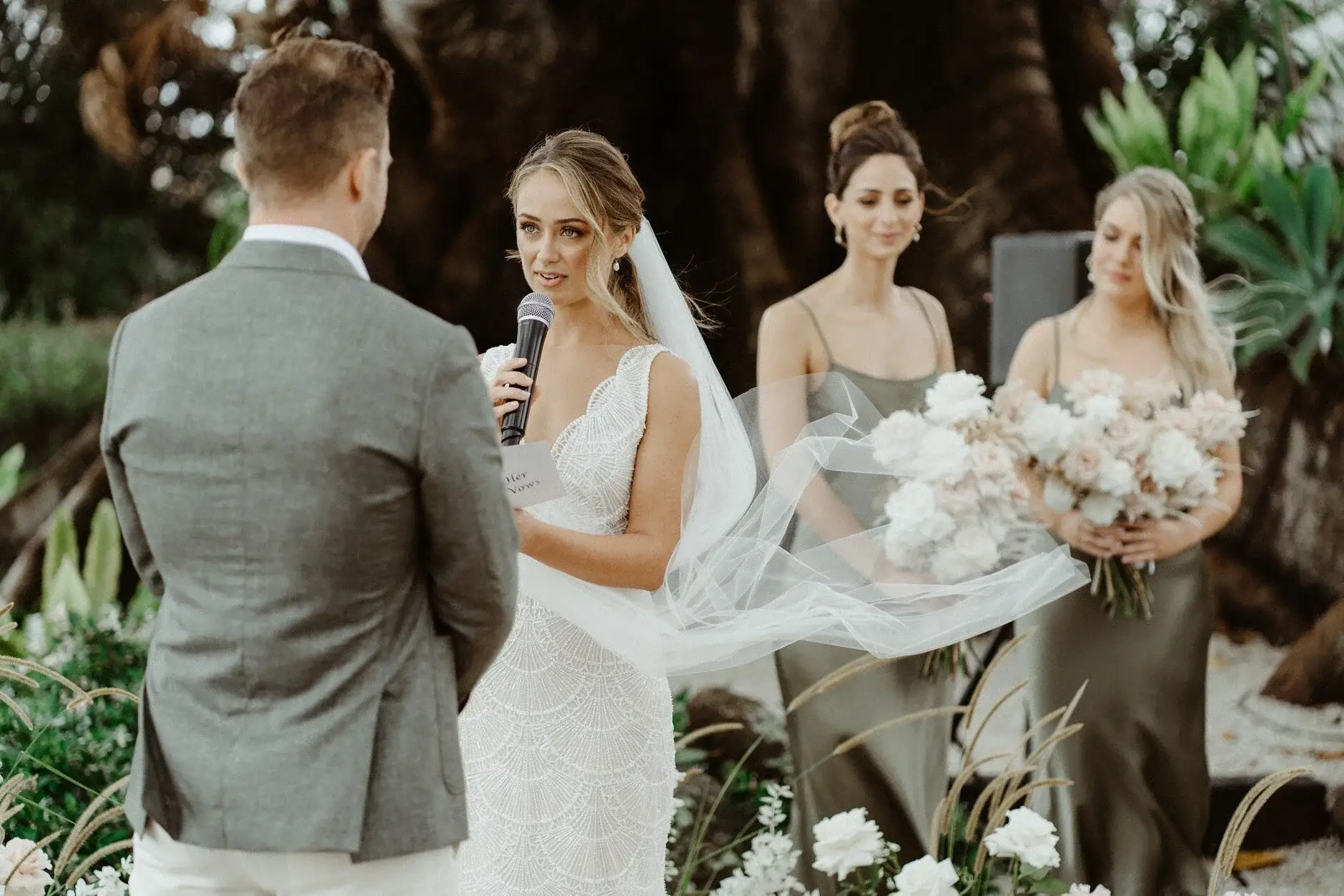 Breanna handing her bouquet to a bridesmaid during the ceremony, The Fig Tree Byron Bay