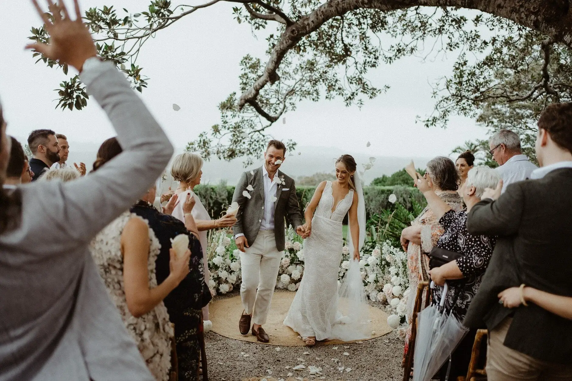 Guests throwing their arms up as the couple kiss, The Fig Tree Byron Bay