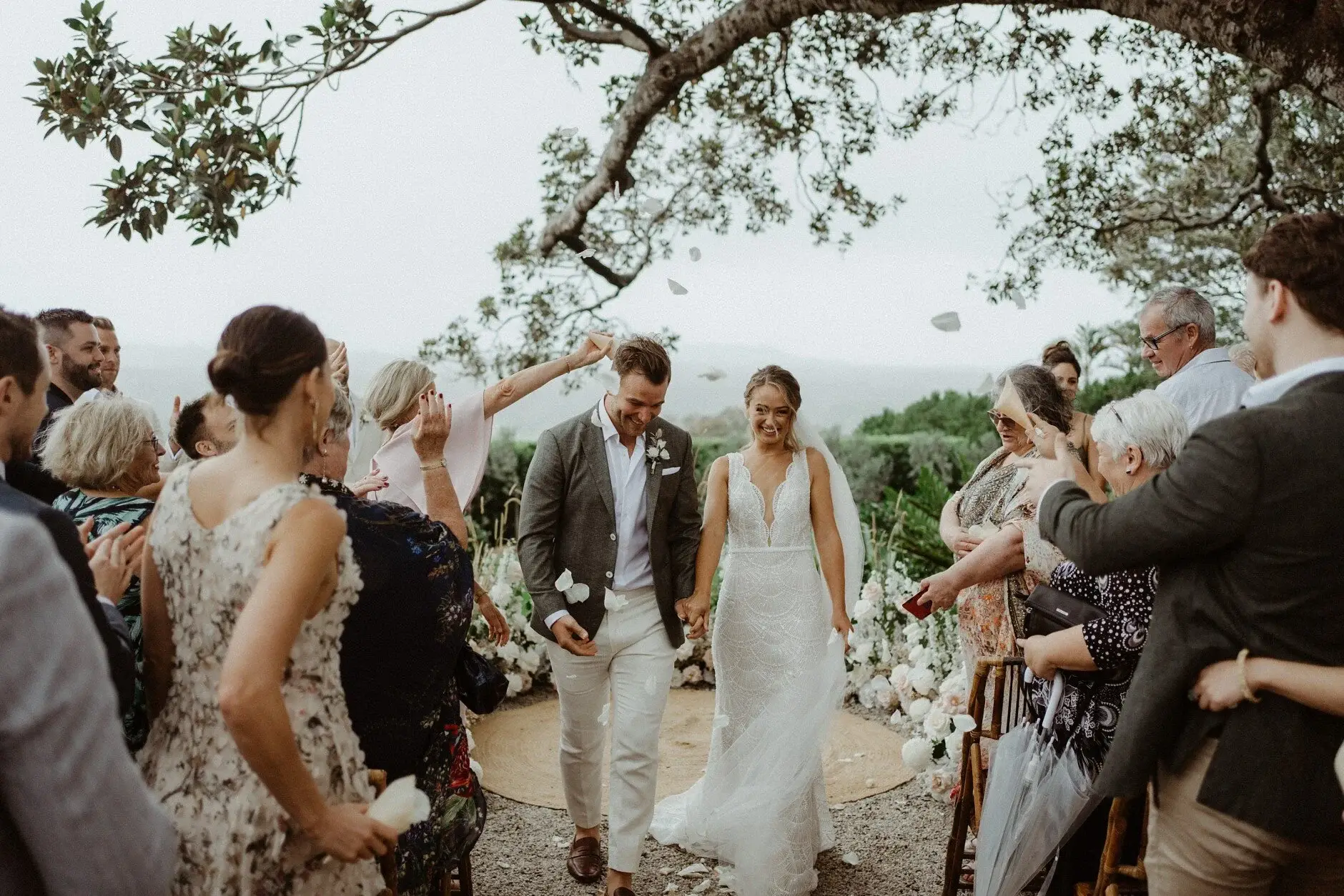 The couple embracing to applause after the ceremony, The Fig Tree Byron Bay