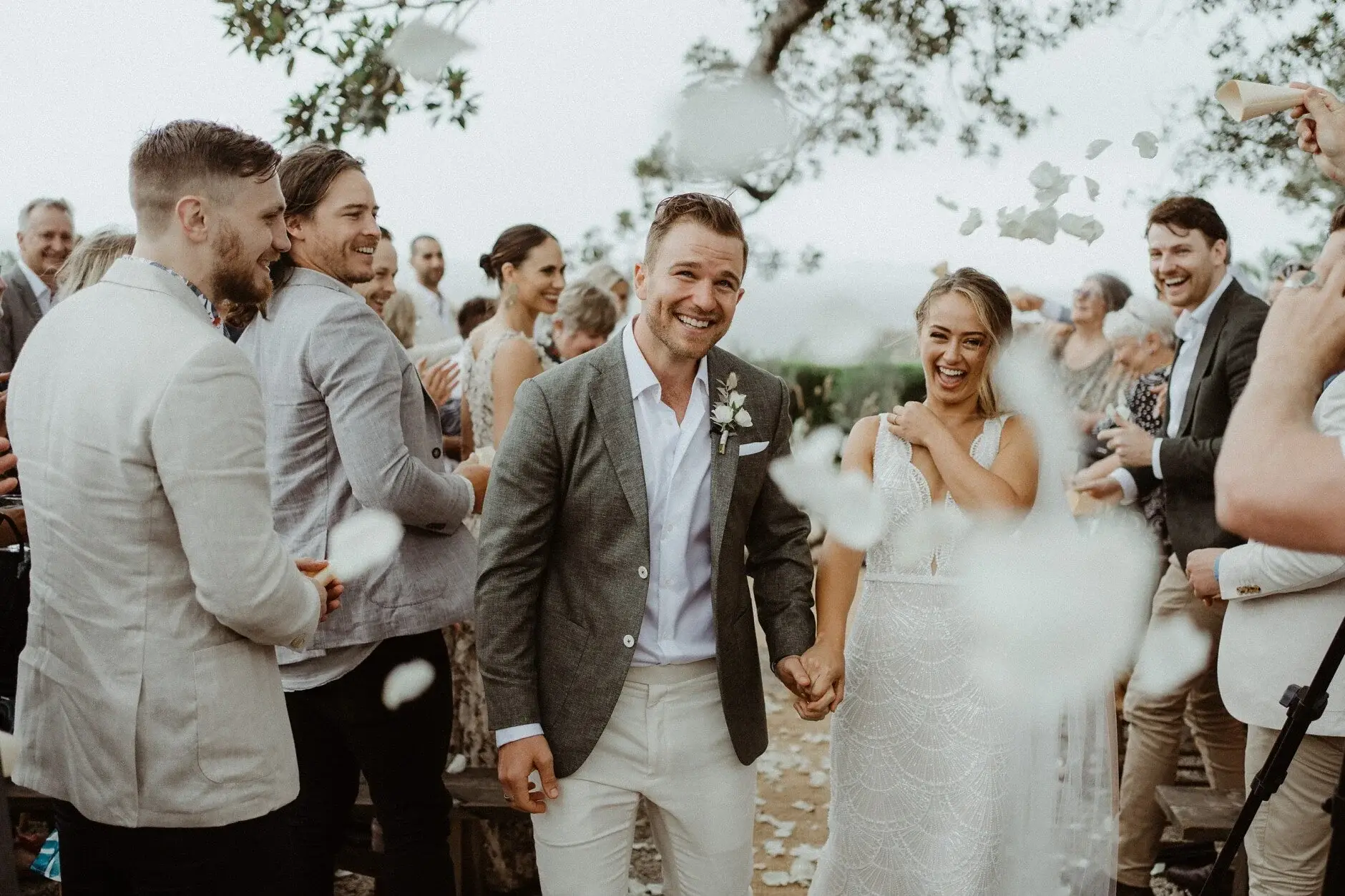 The couple hand in hand among their guests after the ceremony, The Fig Tree Byron Bay