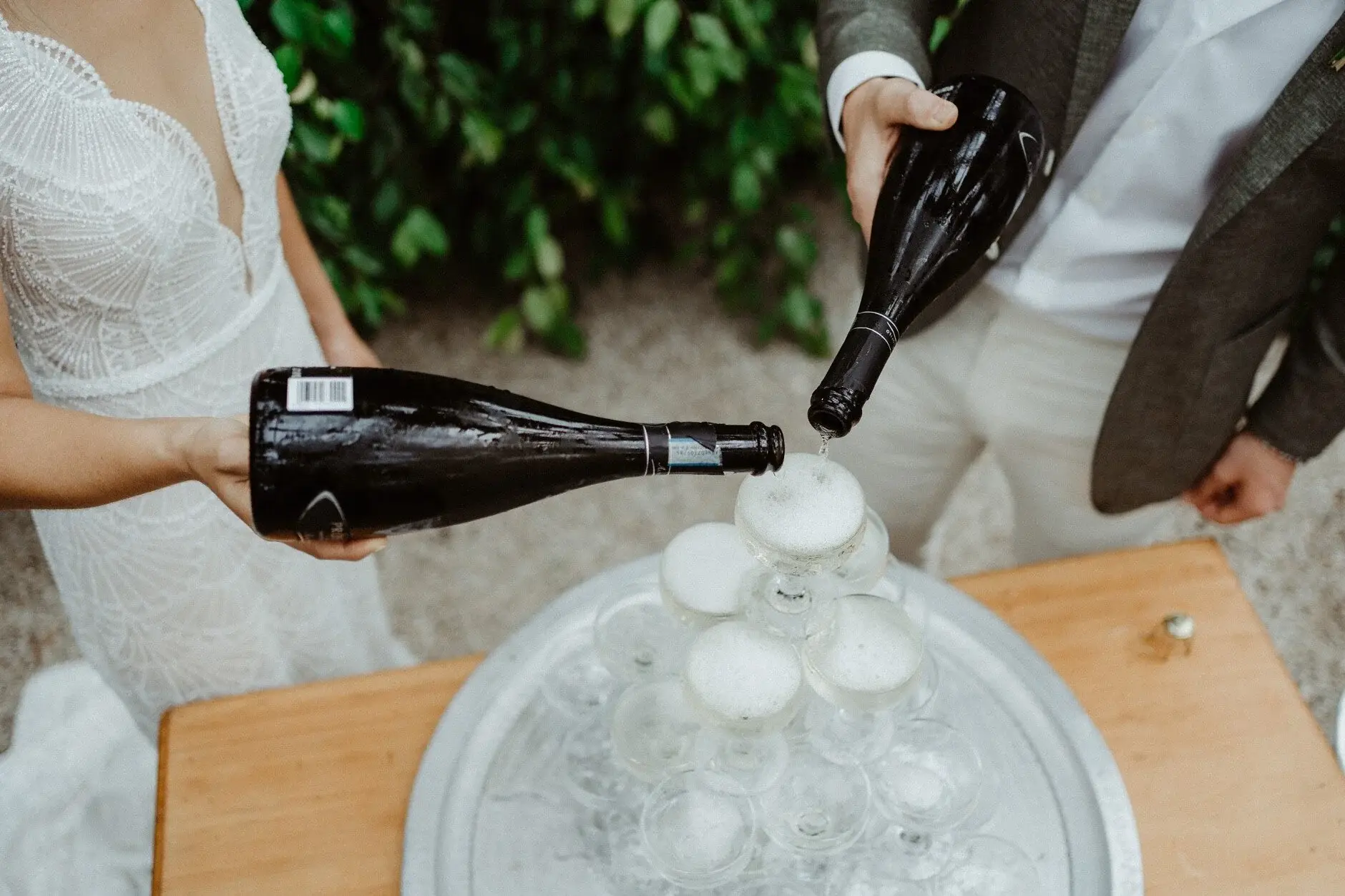 Hands guiding the bottle as champagne runs down the glasses, The Fig Tree Byron Bay