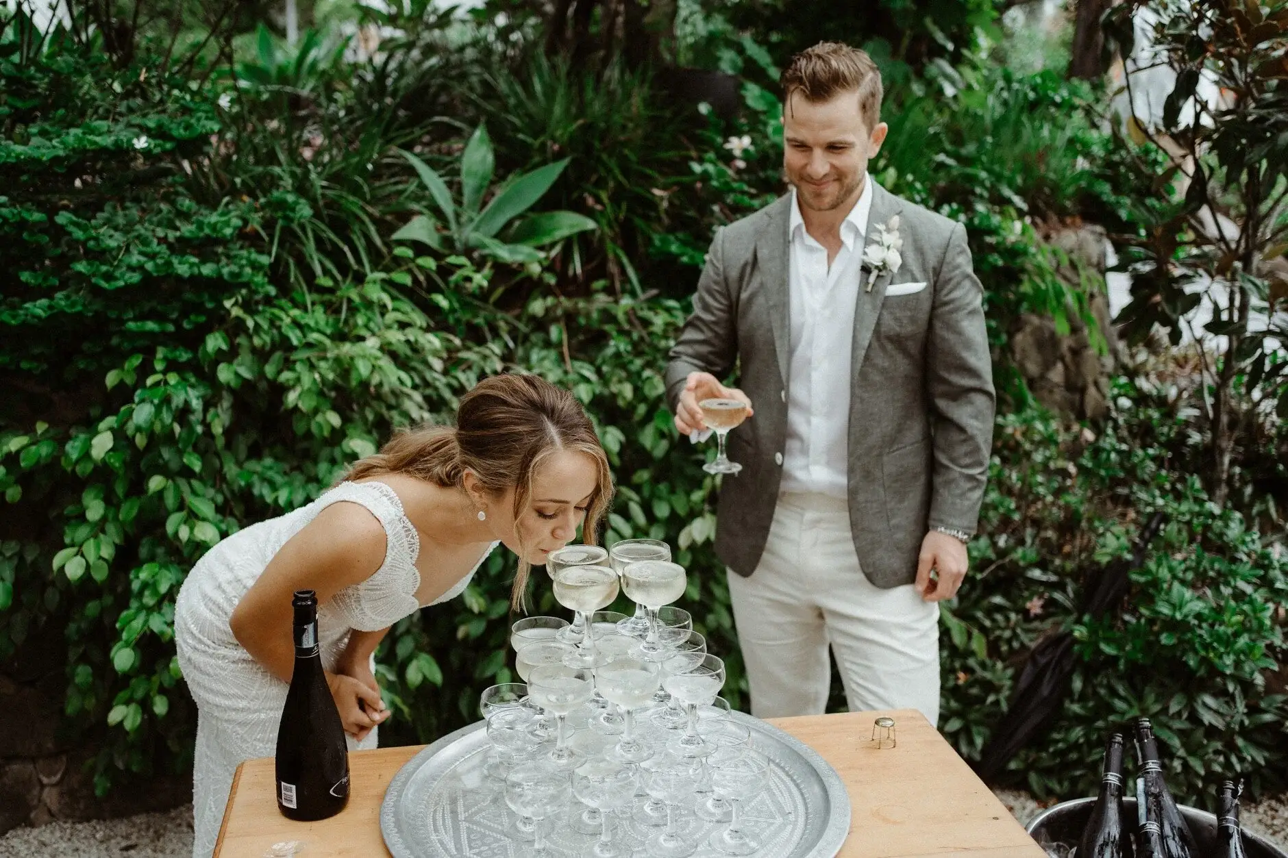 Breanna and Matt laughing over the champagne tower, The Fig Tree Byron Bay