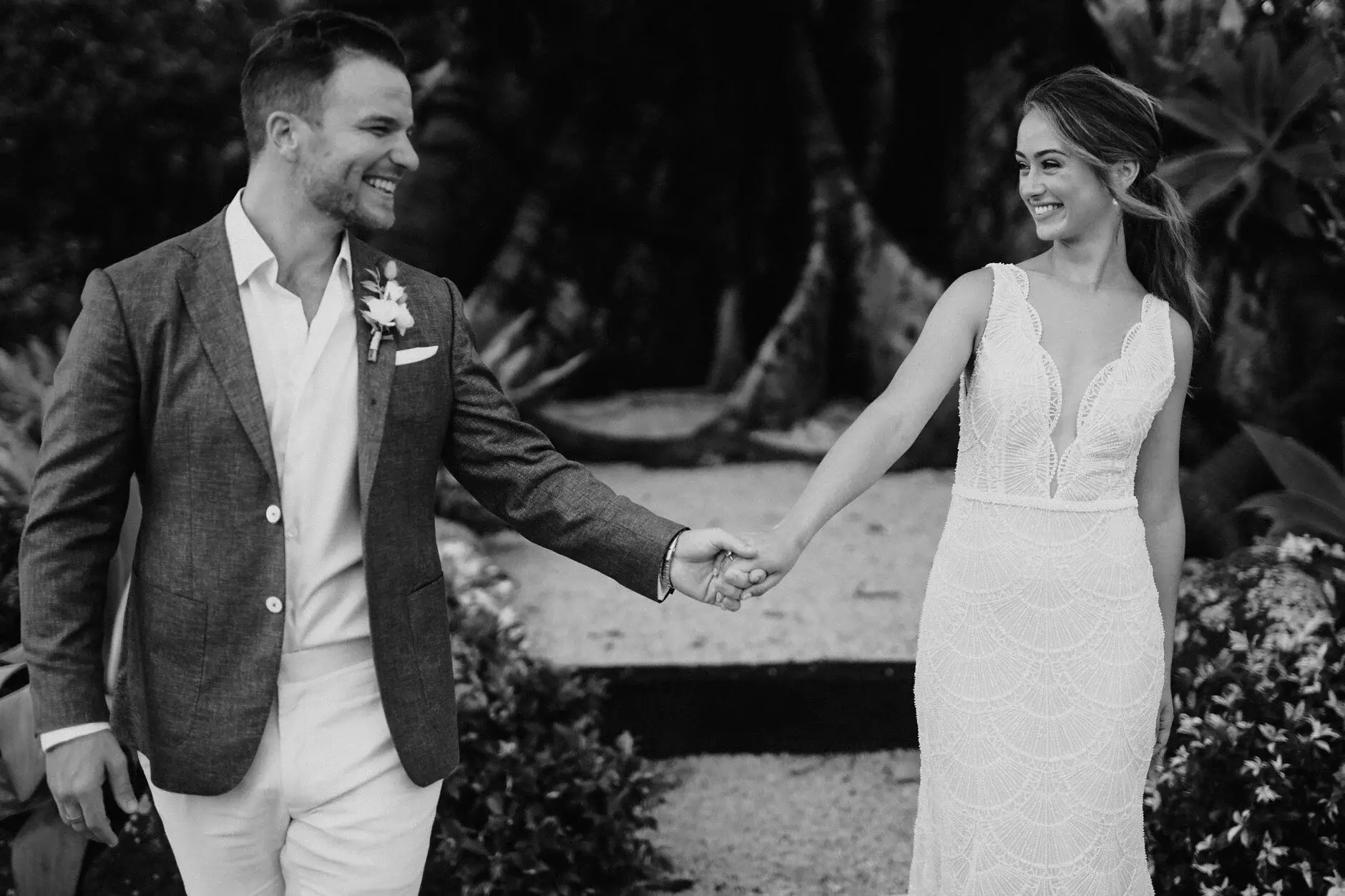 A black-and-white frame of Breanna and Matt walking hand in hand, Byron Bay