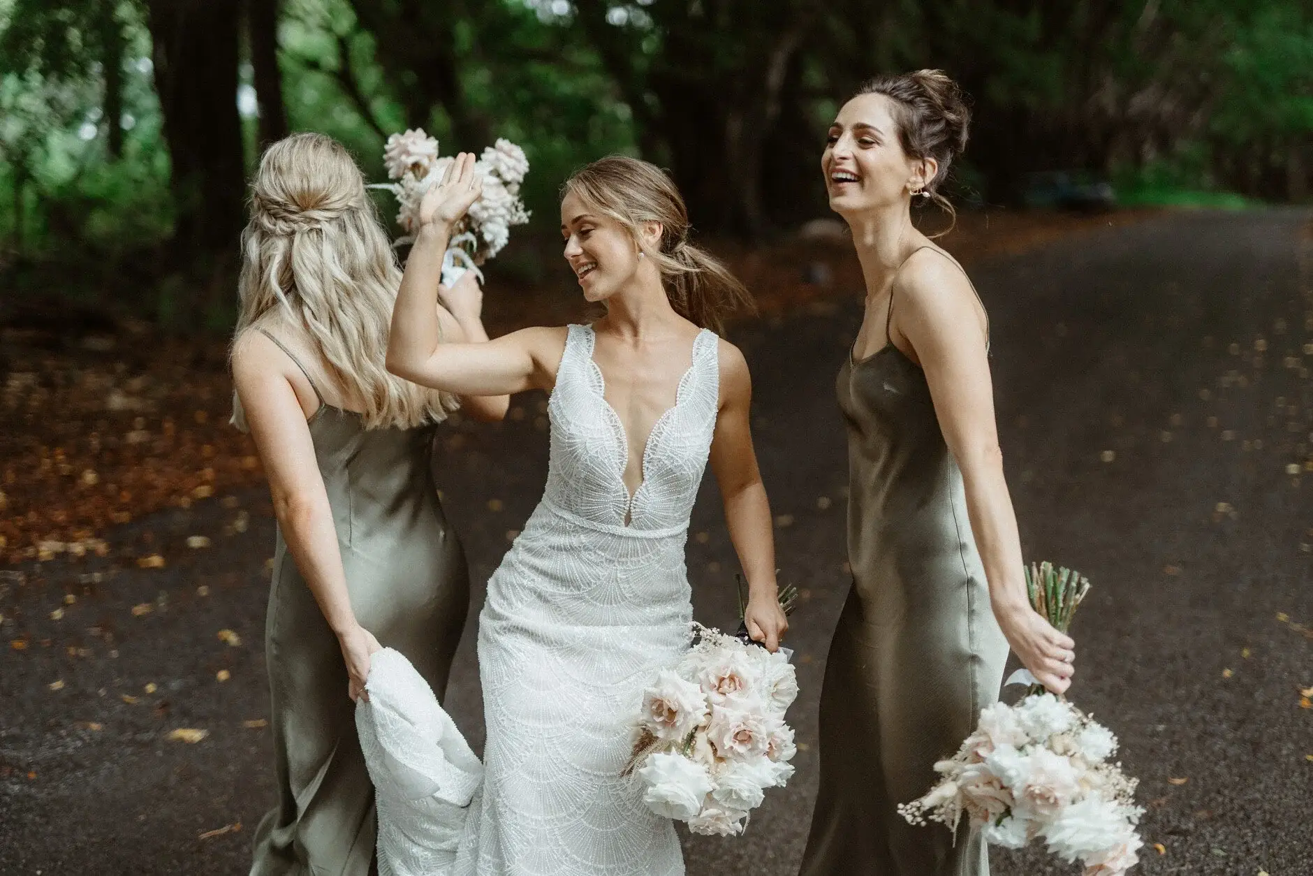 Breanna and her bridesmaids laughing together with their bouquets, Byron Bay