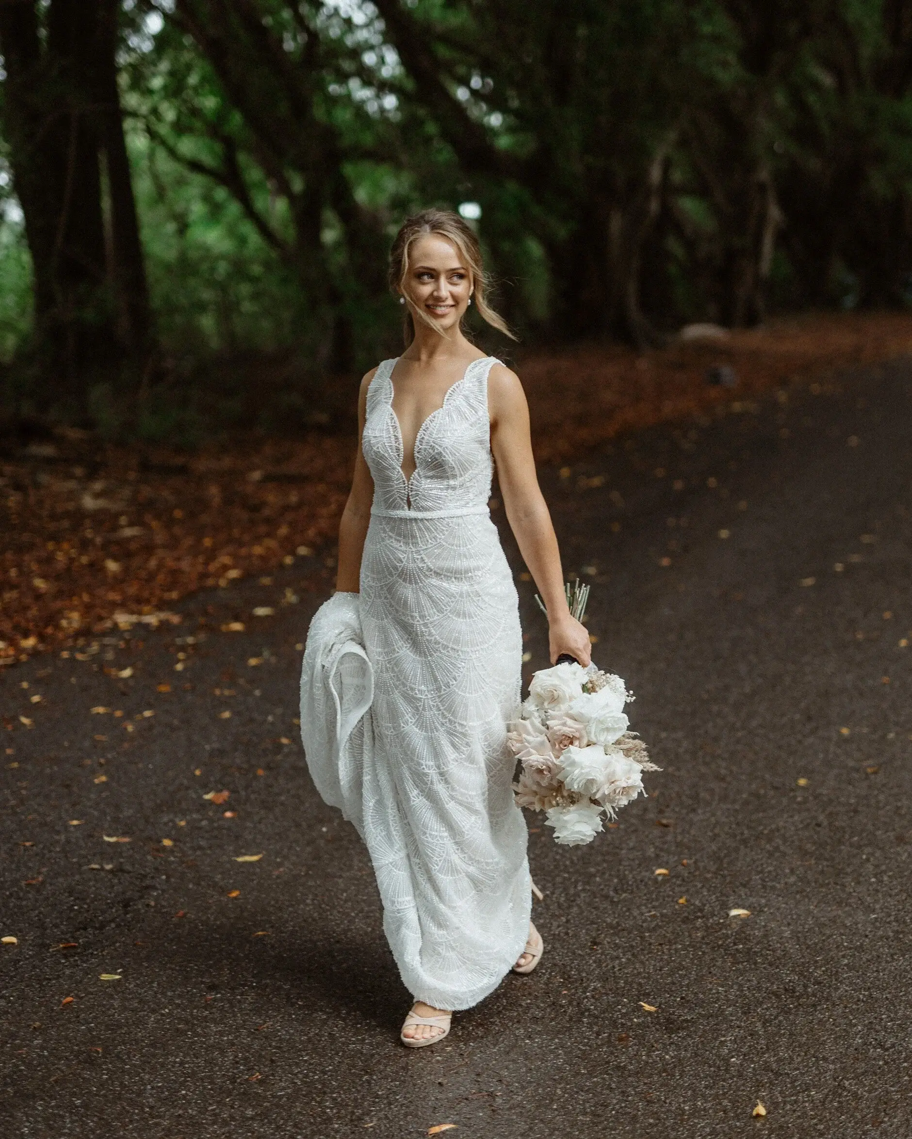 Breanna walking barefoot down the drive with her bouquet, Byron Bay