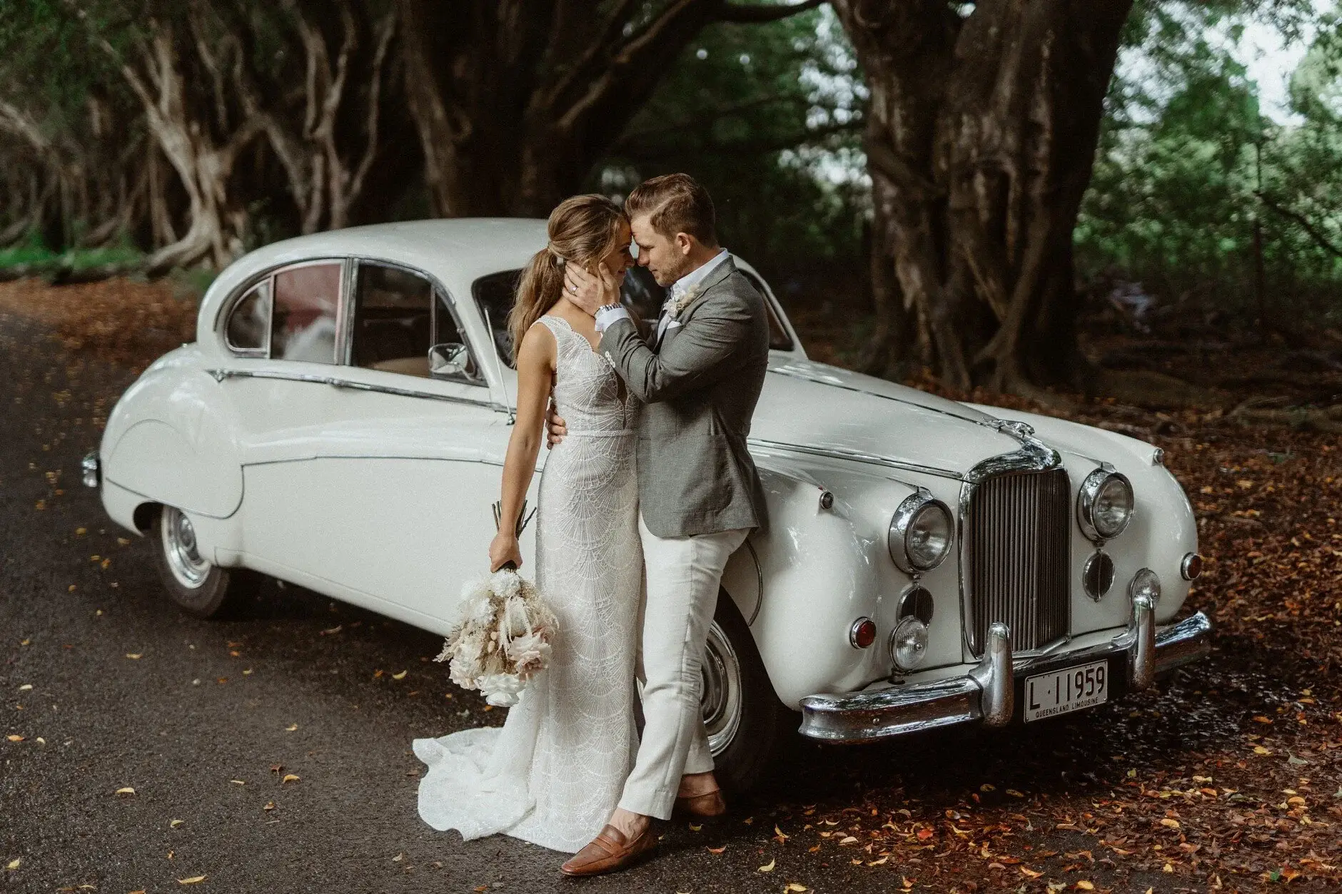 Breanna and Matt beside the white vintage Jaguar, Byron Bay