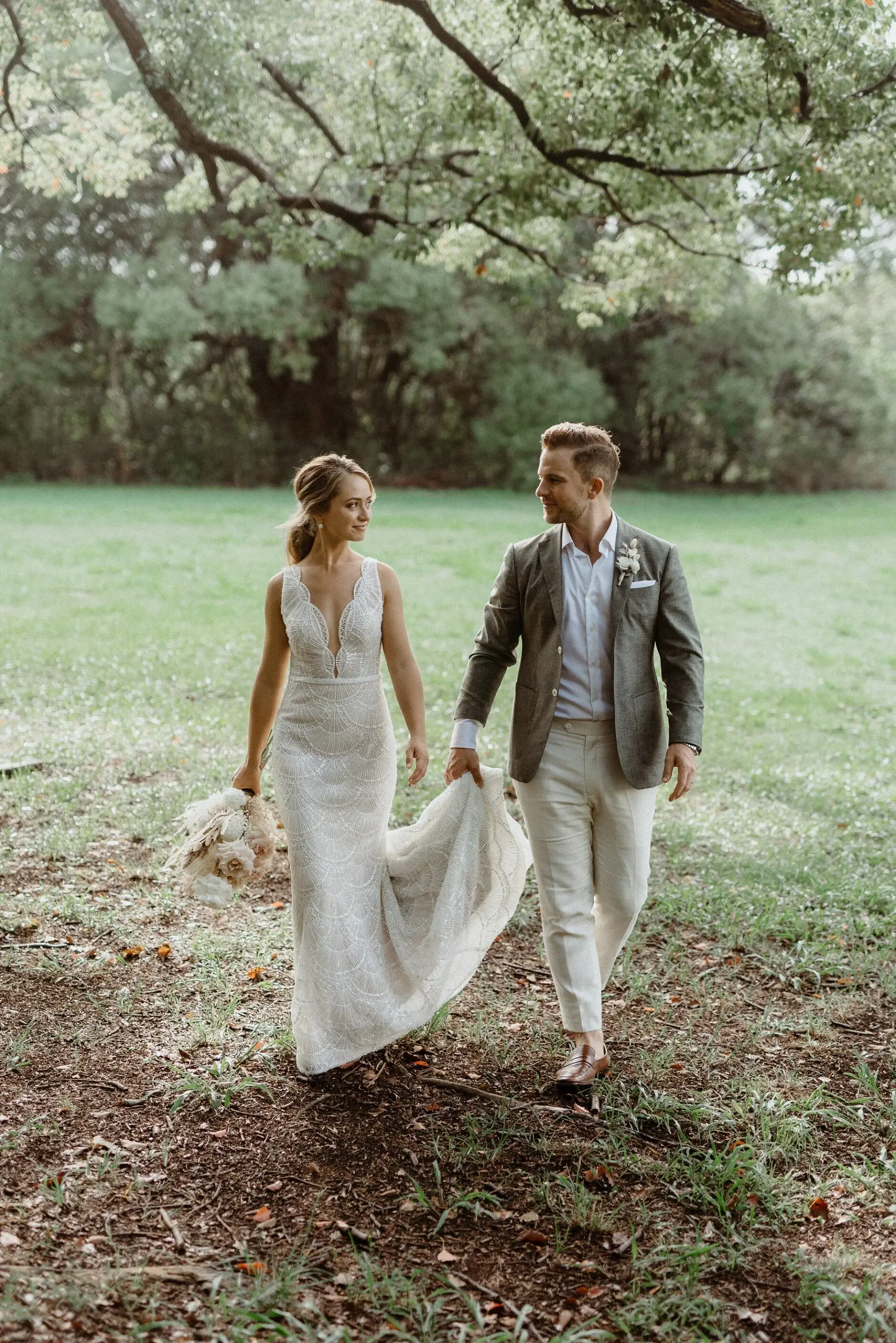 Breanna and Matt walking together beneath the trees, Byron Bay