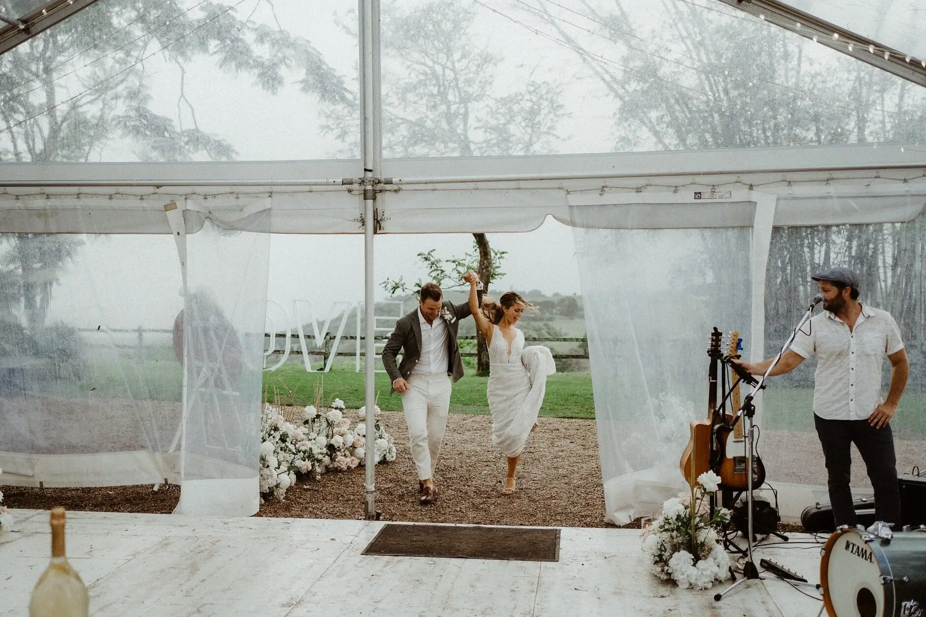 Matt walking through the marquee with a bottle in each hand, Byron View Farm