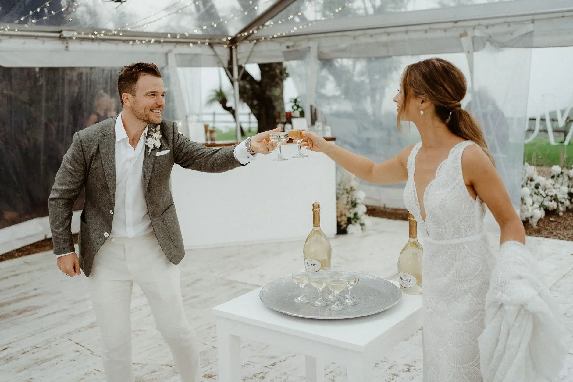 The couple raising a glass to each other in the marquee, Byron View Farm