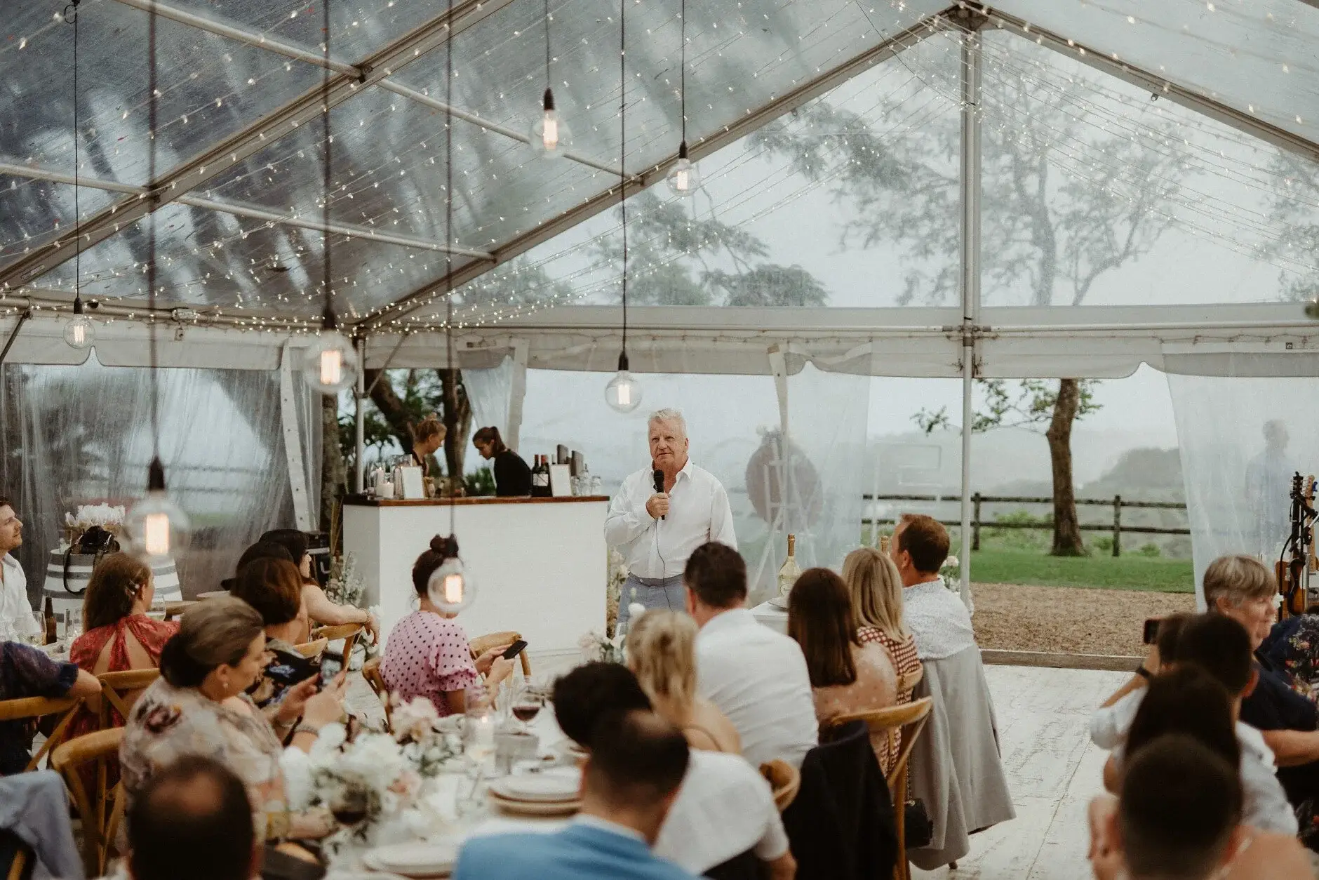 Guests seated at the long tables under the marquee, Byron View Farm