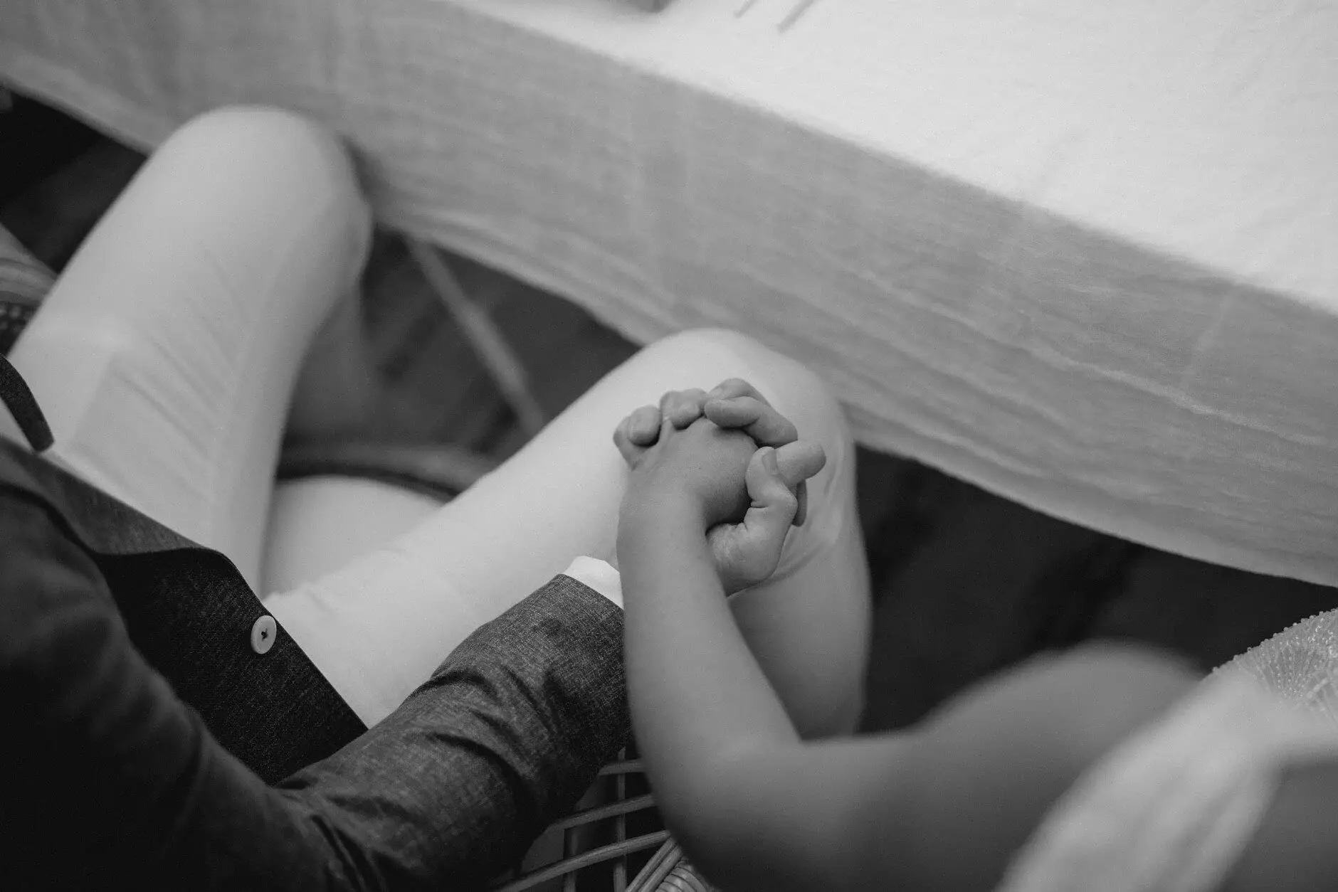 Breanna and Matt holding hands under the table, black and white, Byron View Farm