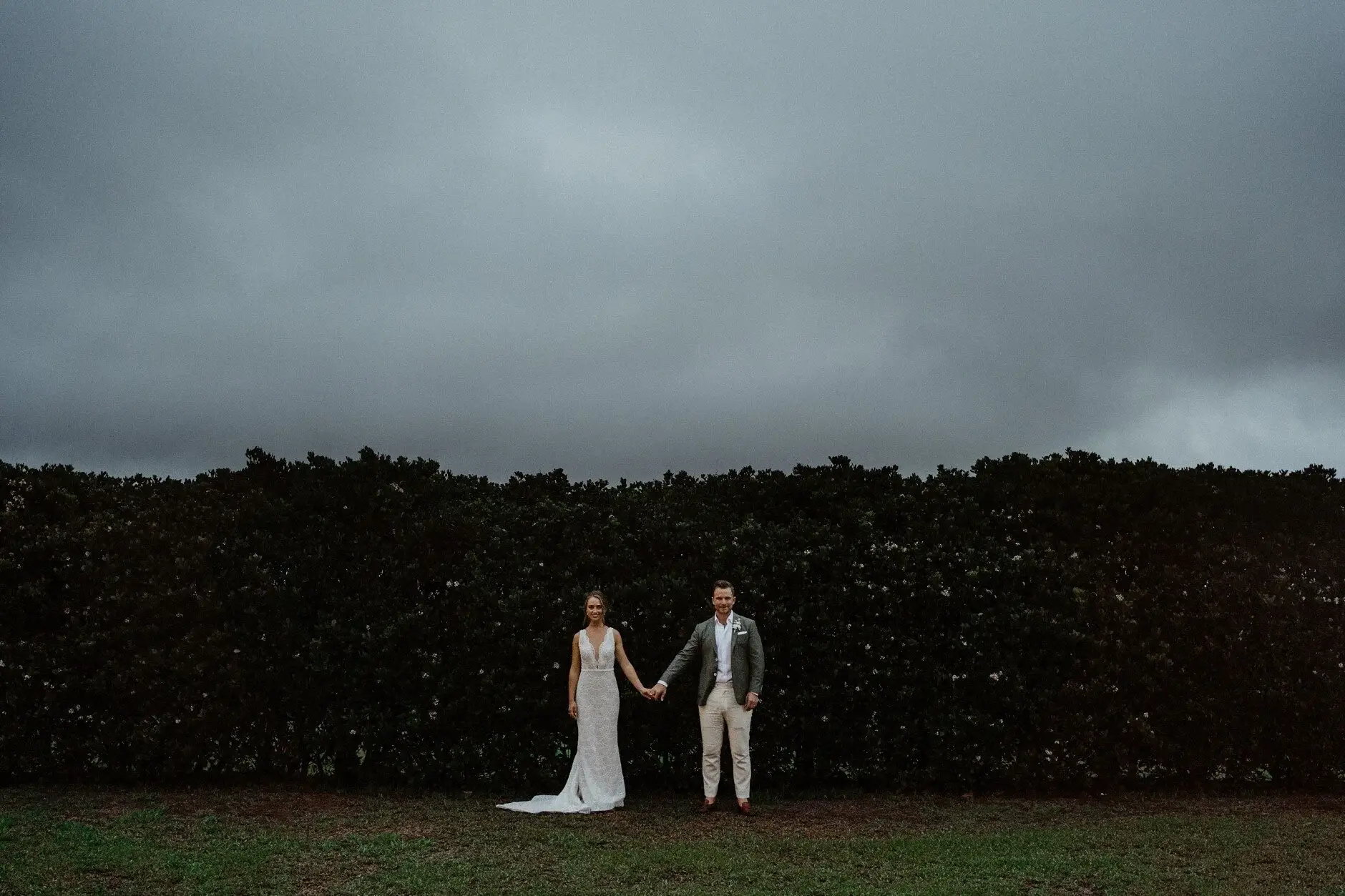 Breanna and Matt small against the stormy evening sky, Byron View Farm