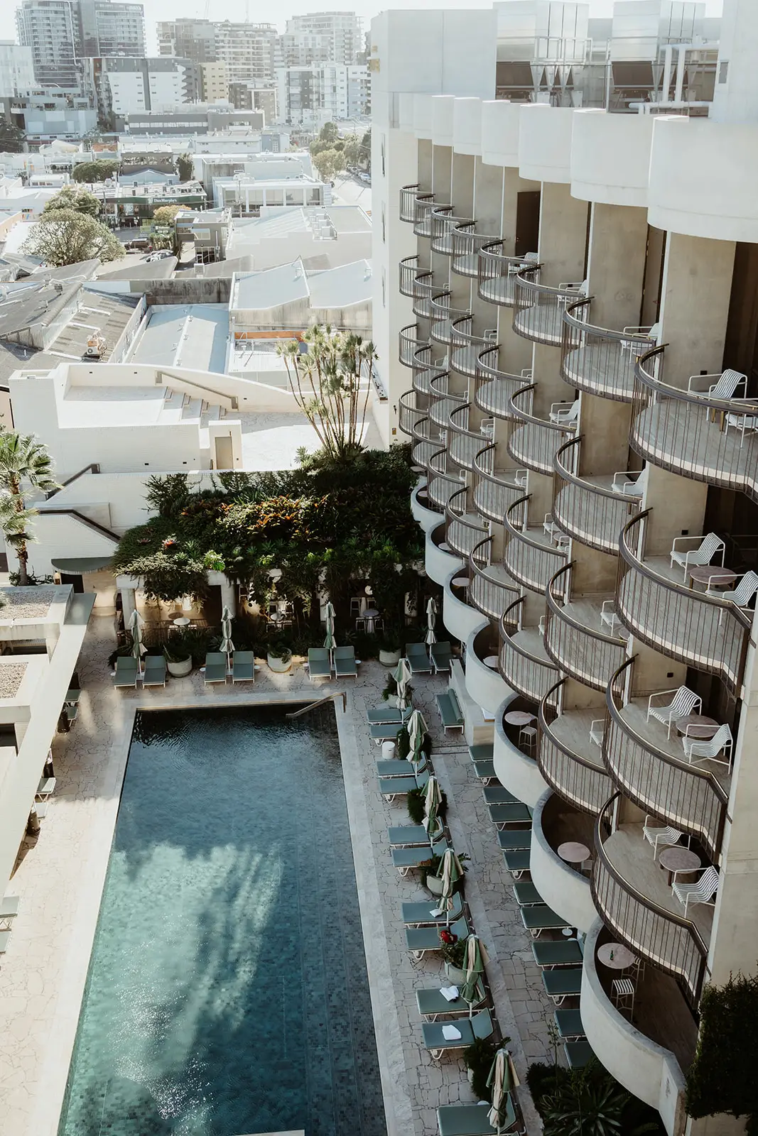 Looking down the length of the pool and its stacked balconies, The Calile Hotel