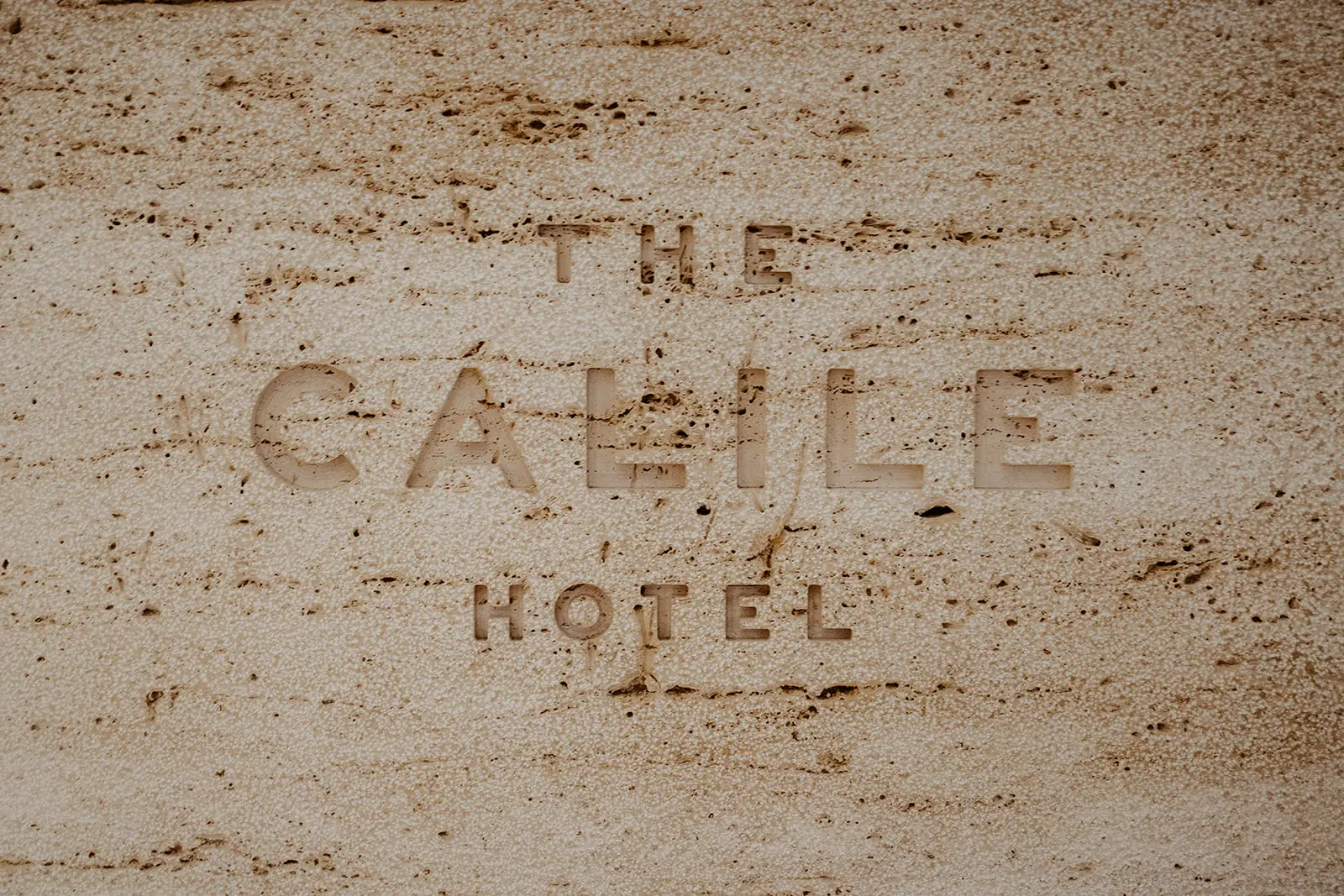 The hotel name cut into travertine at the entrance, The Calile Hotel