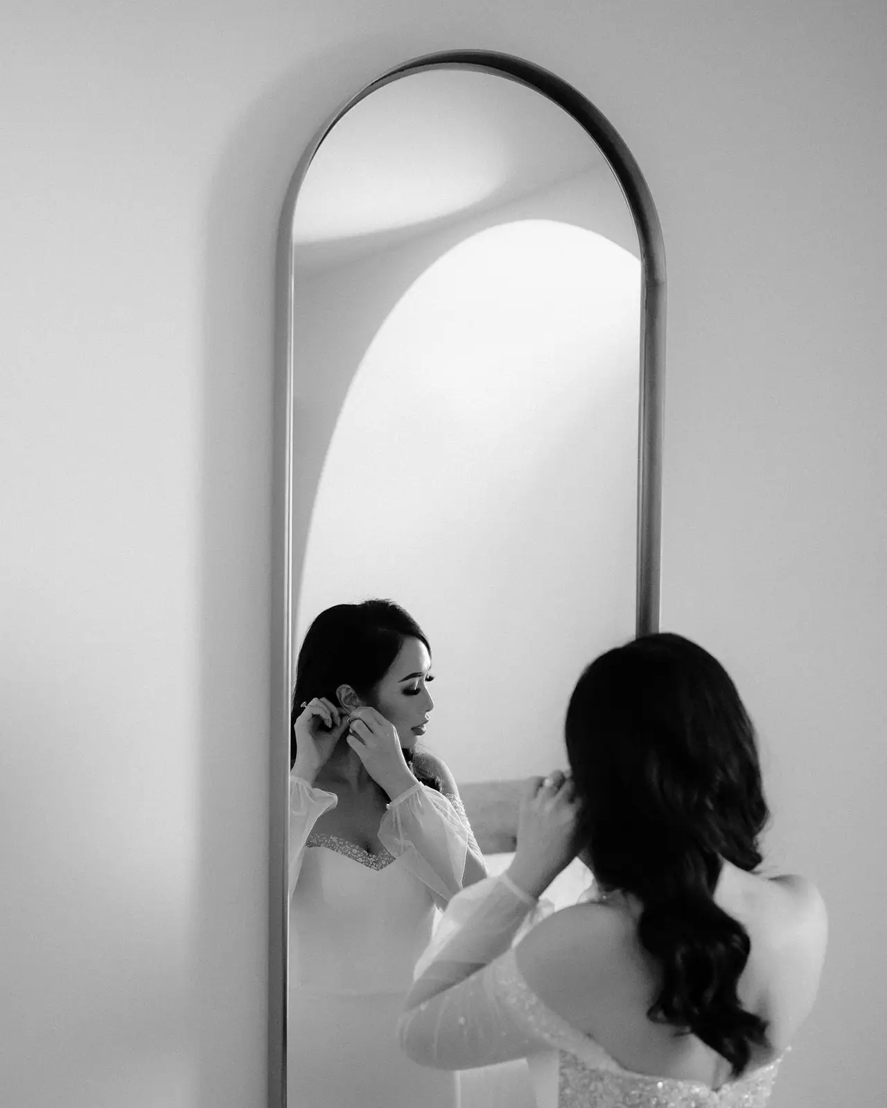 Black and white — earrings going on at the arched mirror, The Calile Hotel
