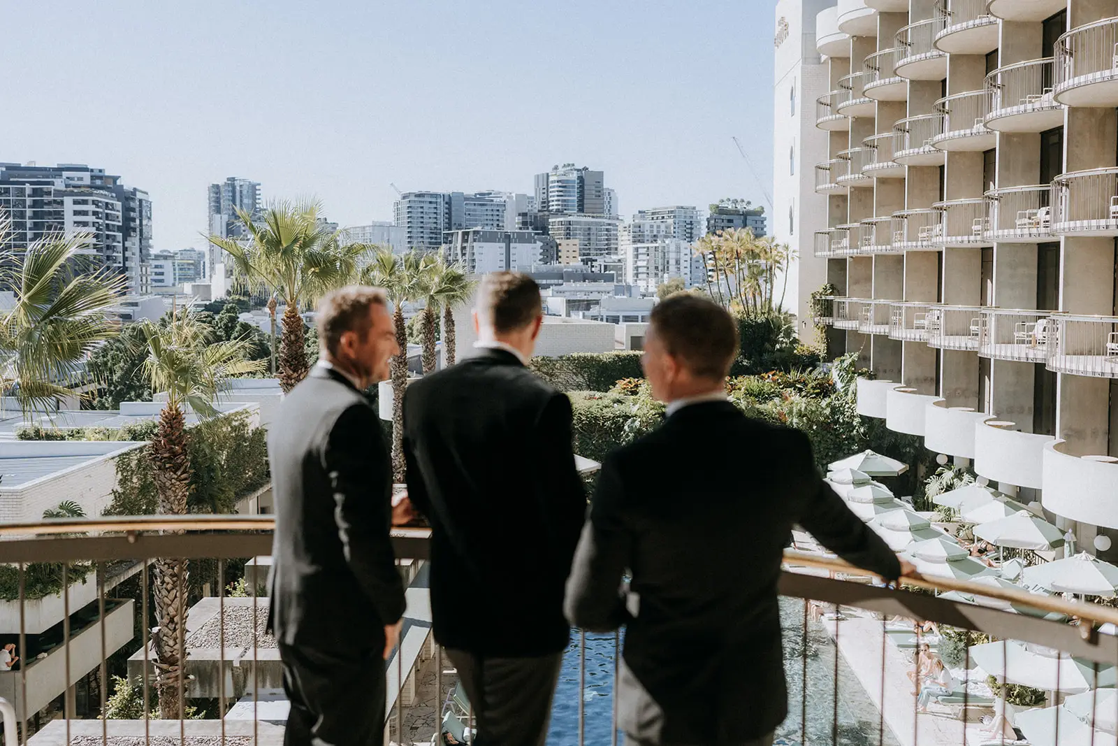 Groomsmen on a balcony above the pool, The Calile Hotel