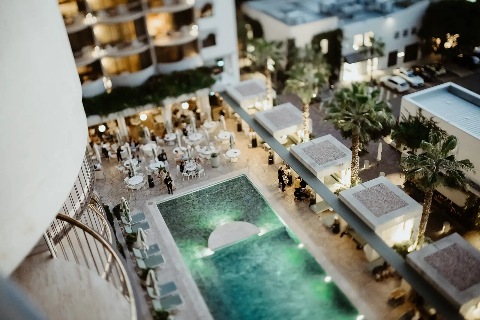 The pool deck and cabanas from above, lit for the evening, The Calile Hotel