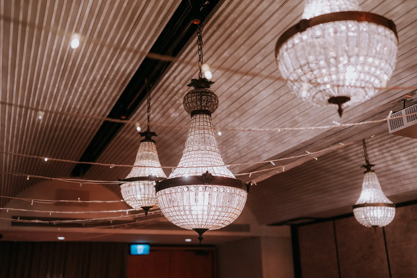 Crystal chandeliers and festoon strings under the ribbed ceiling of the reception room, The Calile Hotel