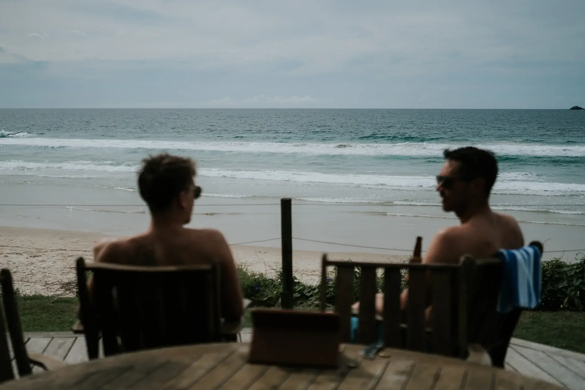Two of the boys in deck chairs looking out at the surf, Belongil Beach