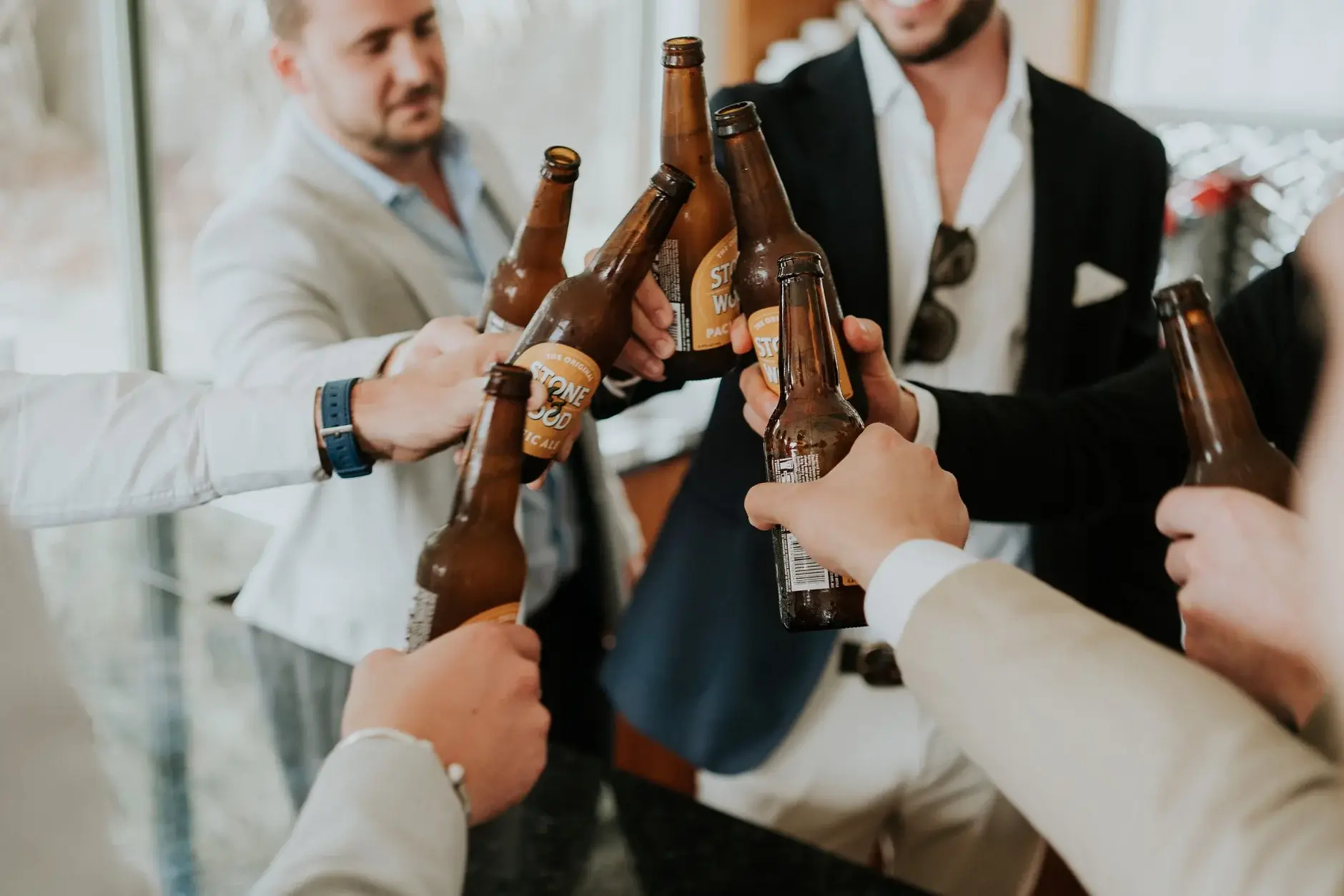 The groomsmen clinking beer bottles together, Belongil Beach