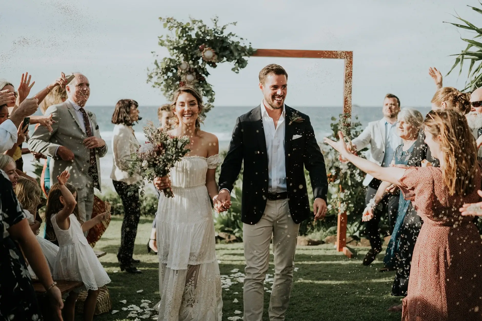 Confetti falling as Cassie and Jack walk back down the aisle, Belongil