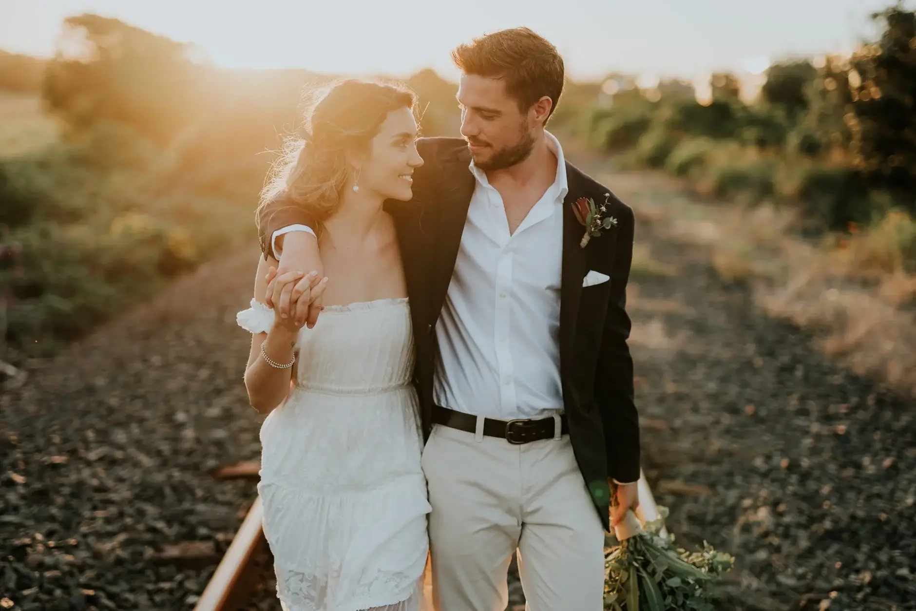 The couple by the tracks, and beside the old red rail carriage