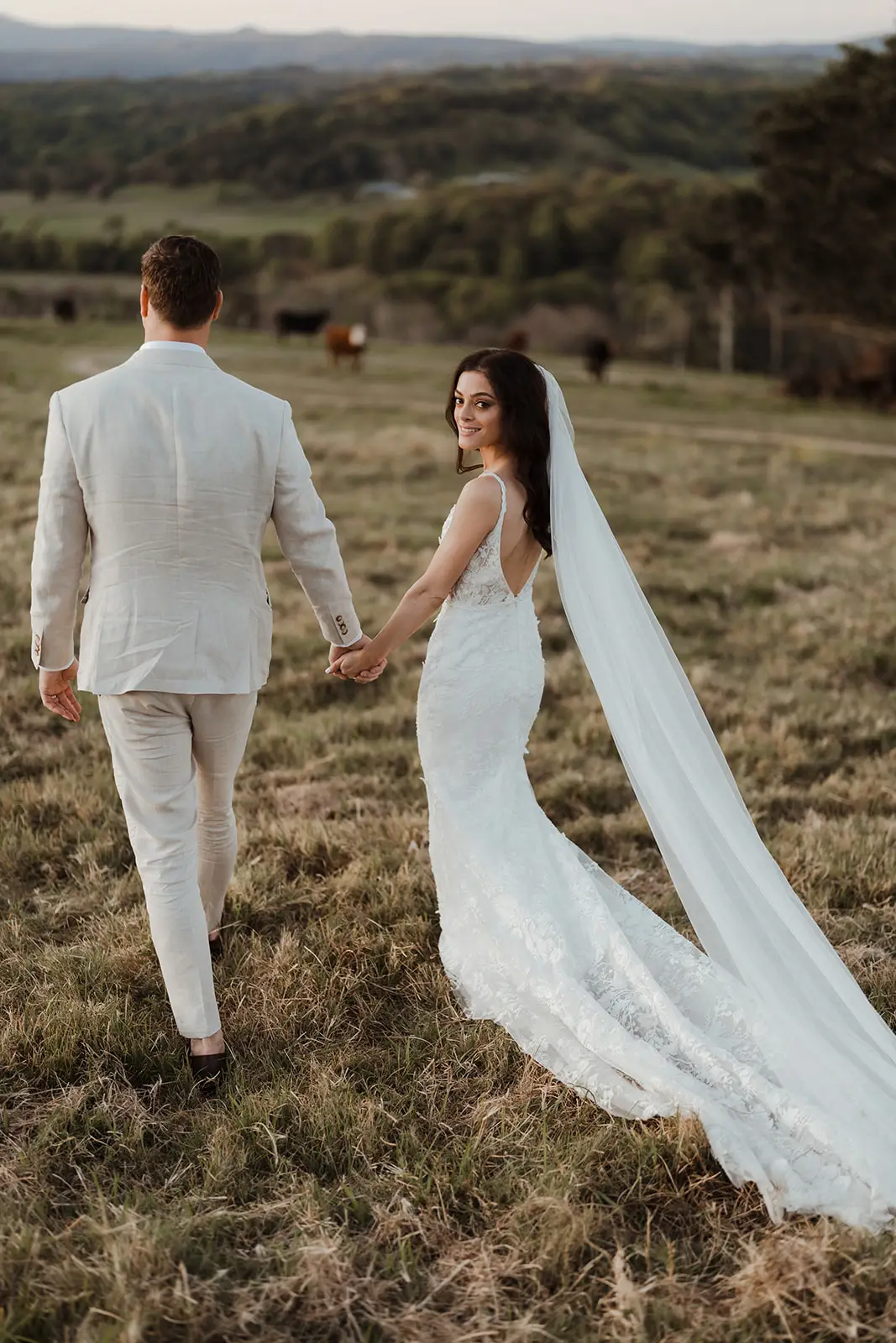 Walking through the long grass with the veil trailing behind, EarthHouse
