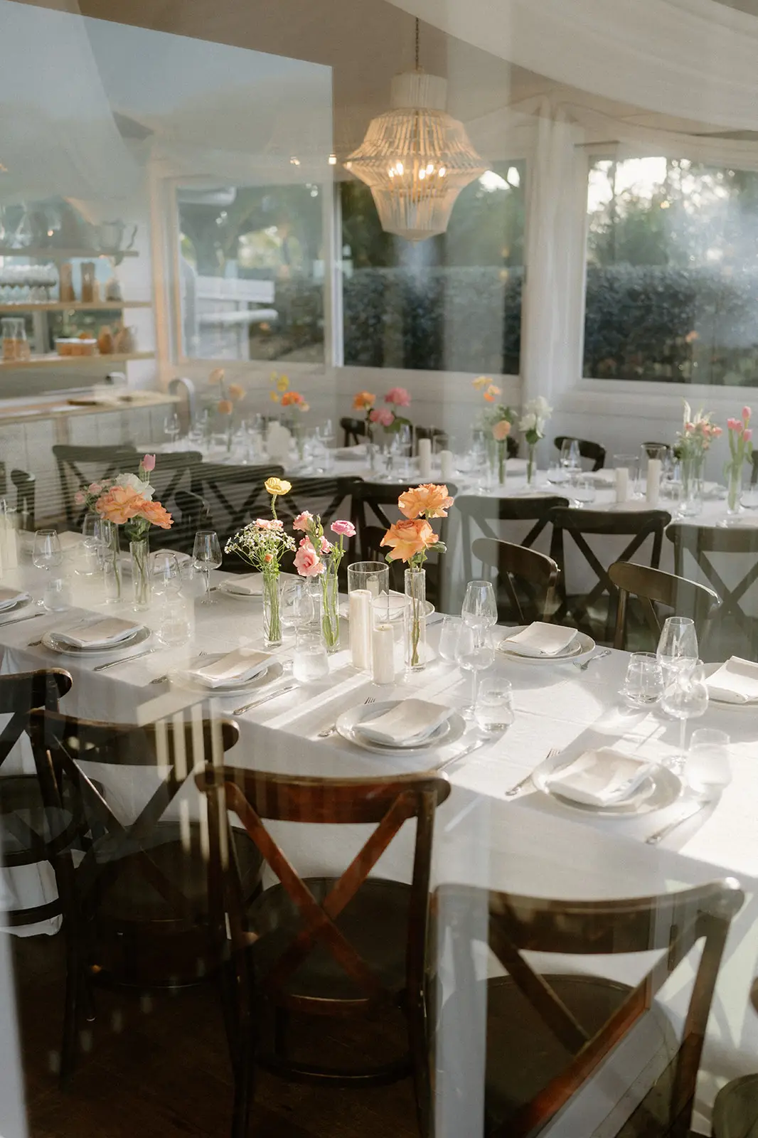 The restaurant set for dinner, cross-back chairs and bud vases down the table, Fig Tree Restaurant