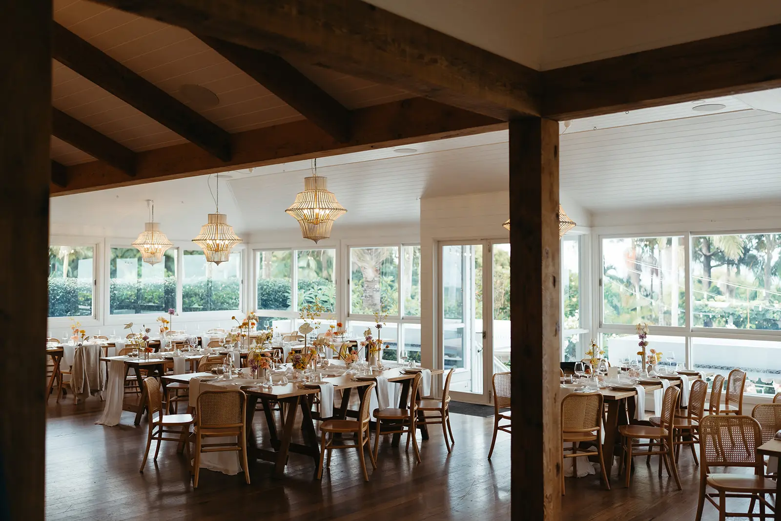 The restaurant from the doorway — round tables, woven pendants and windows to the view, Fig Tree Restaurant